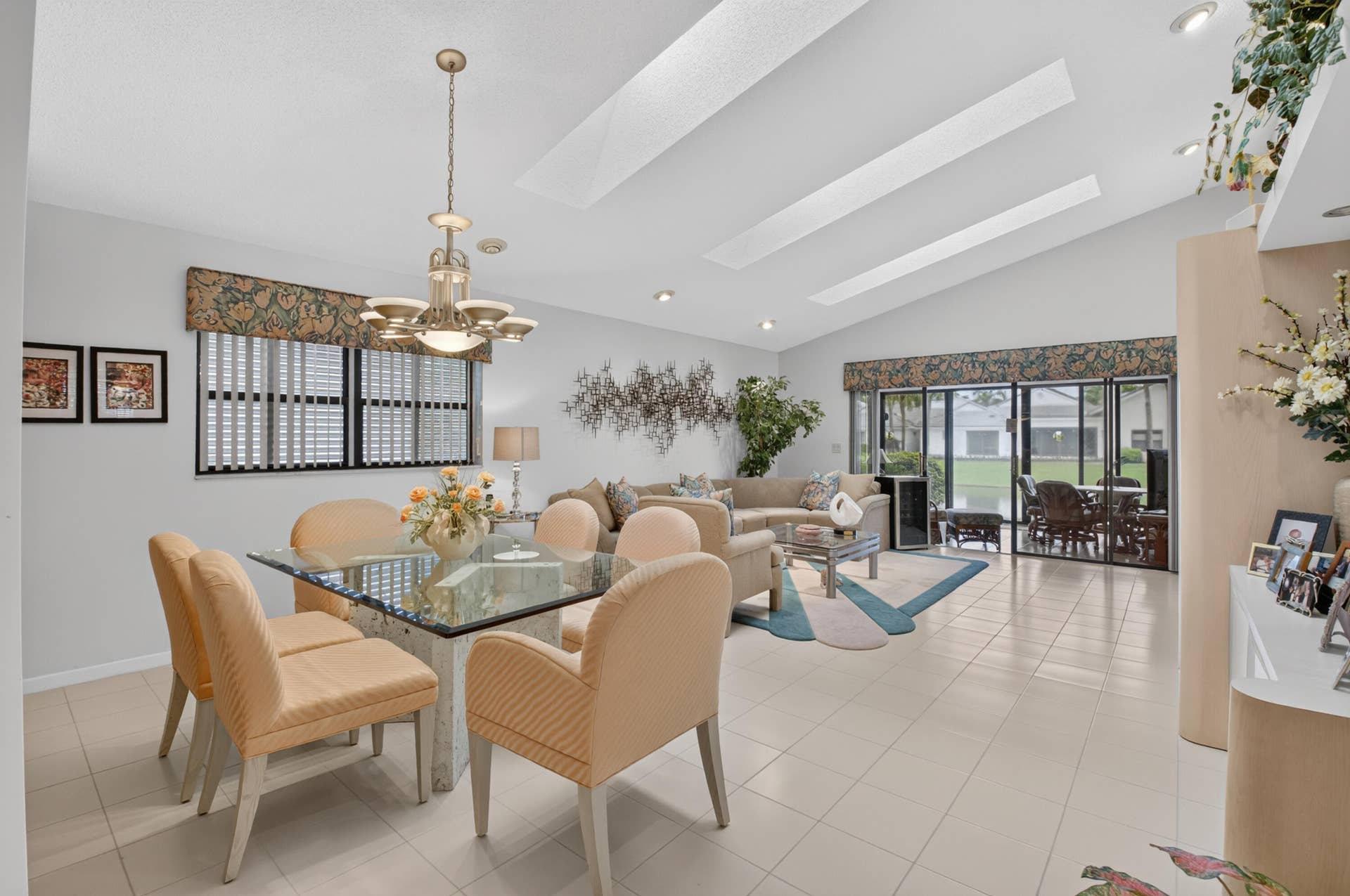 20065 Waters Edge Drive, #101, Boca Raton, FL 33434 Vaulted ceilings with recessed lighting, large glass slider, ceramic tile flooring, and a dining area chandelier