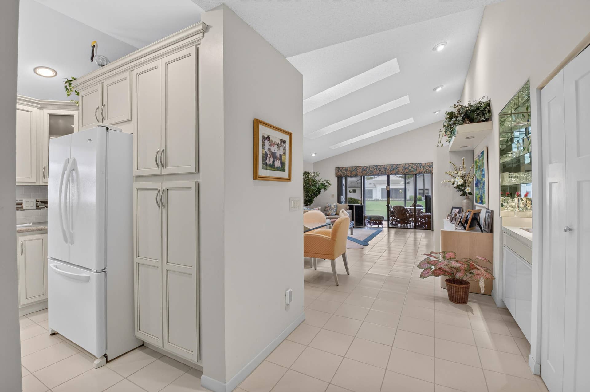 20065 Waters Edge Drive, #101, Boca Raton, FL 33434 Vaulted ceilings with recessed lighting, large format floor tiling, white built-in cabinetry, and integrated shelving