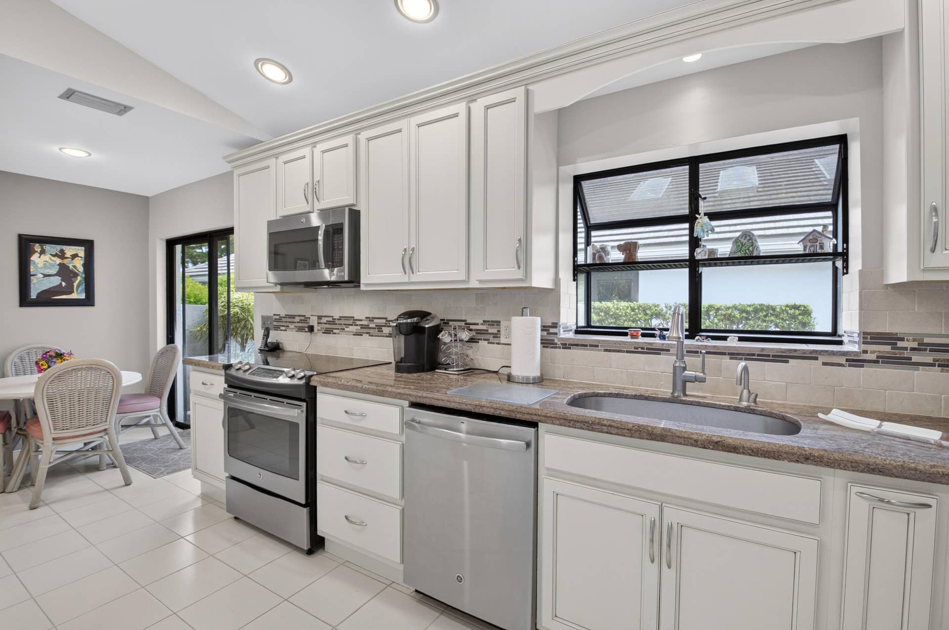 20065 Waters Edge Drive, #101, Boca Raton, FL 33434 Kitchen featuring white cabinetry, stainless steel appliances, a tiled backsplash, a built-in sink, and recessed lighting