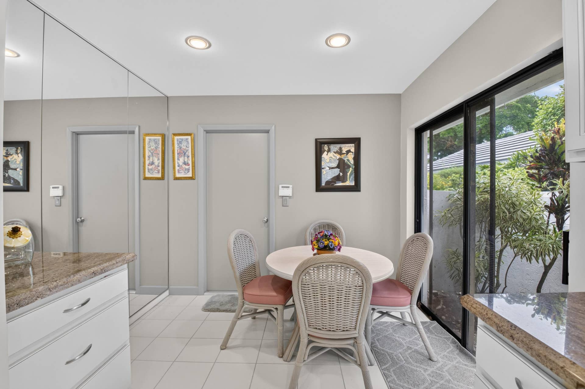 20065 Waters Edge Drive, #101, Boca Raton, FL 33434 White tile flooring, recessed lighting, mirrored wall, granite-finish countertops, and sliding glass doors