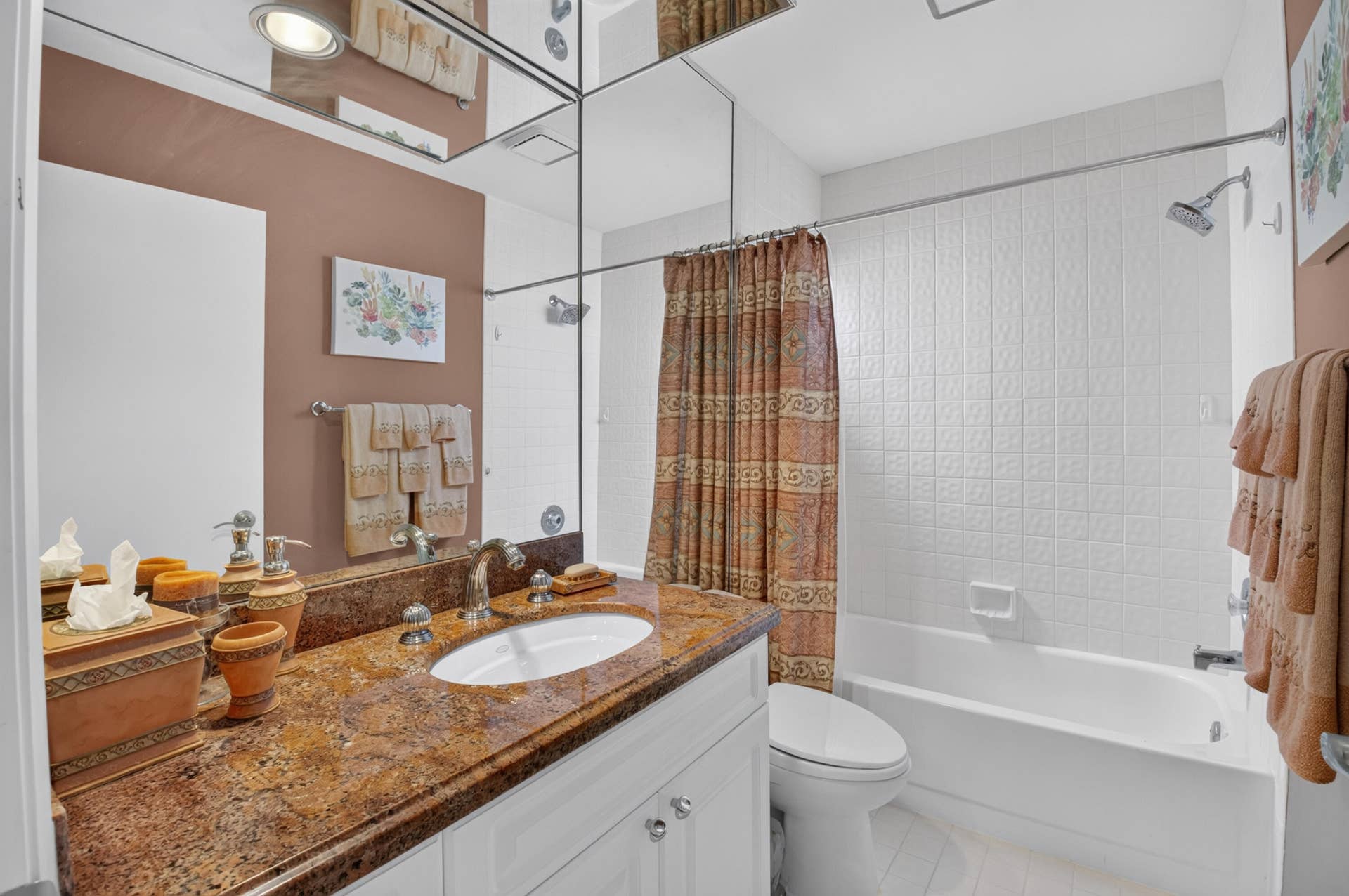 20065 Waters Edge Drive, #101, Boca Raton, FL 33434 Bathroom featuring a single vanity with a patterned countertop, white cabinetry, an undermount sink, and a mirrored wall