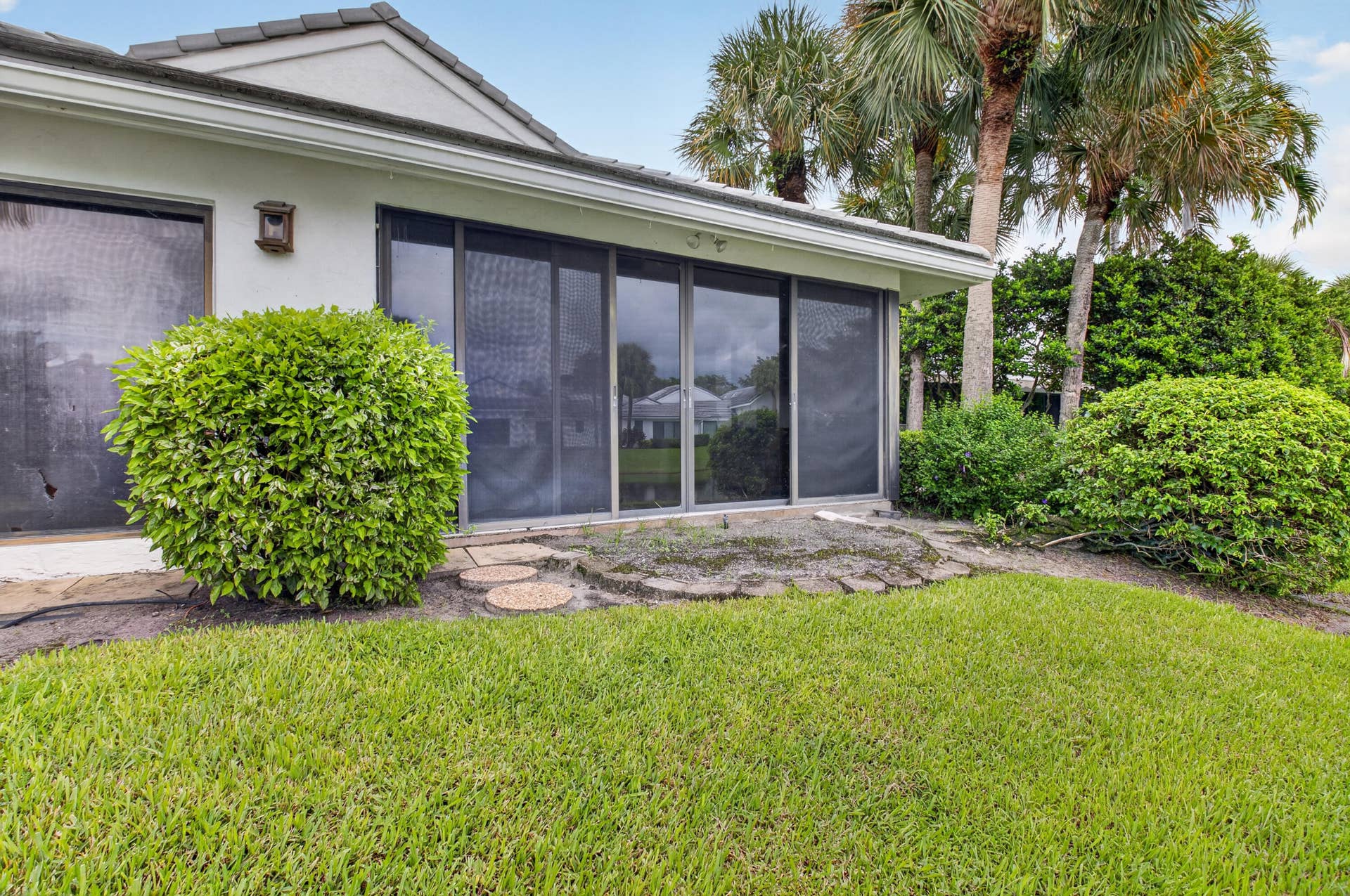 20065 Waters Edge Drive, #101, Boca Raton, FL 33434 Modern residence showcasing expansive manicured lawn, mature palm trees, and professionally landscaped foundation plantings