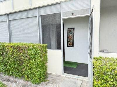 145 Dorchester G, West Palm Beach, FL 33417 The screen porch has a door for access to outside.