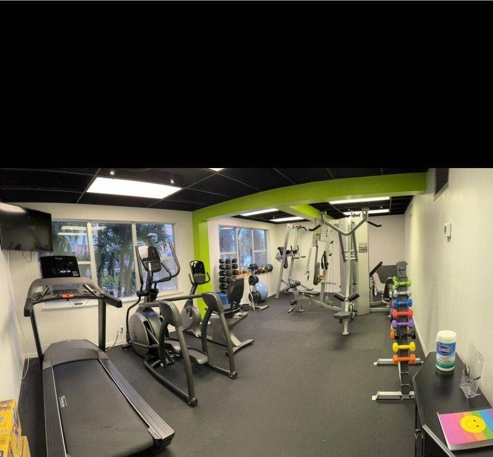 Dedicated fitness area featuring black ceiling panels, recessed lighting, and expansive windows