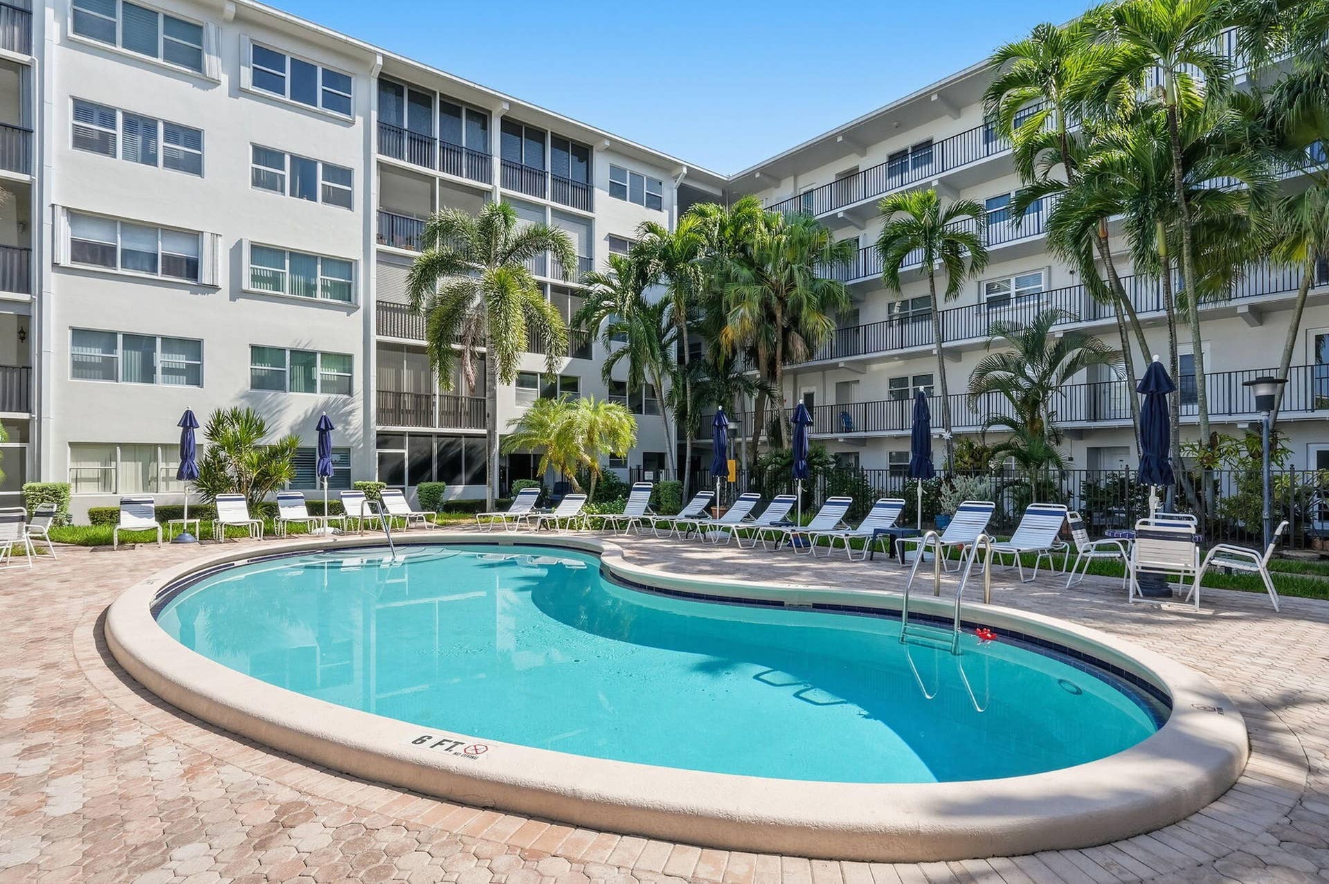 Resort-style pool with integrated steps, surrounded by a paver deck
