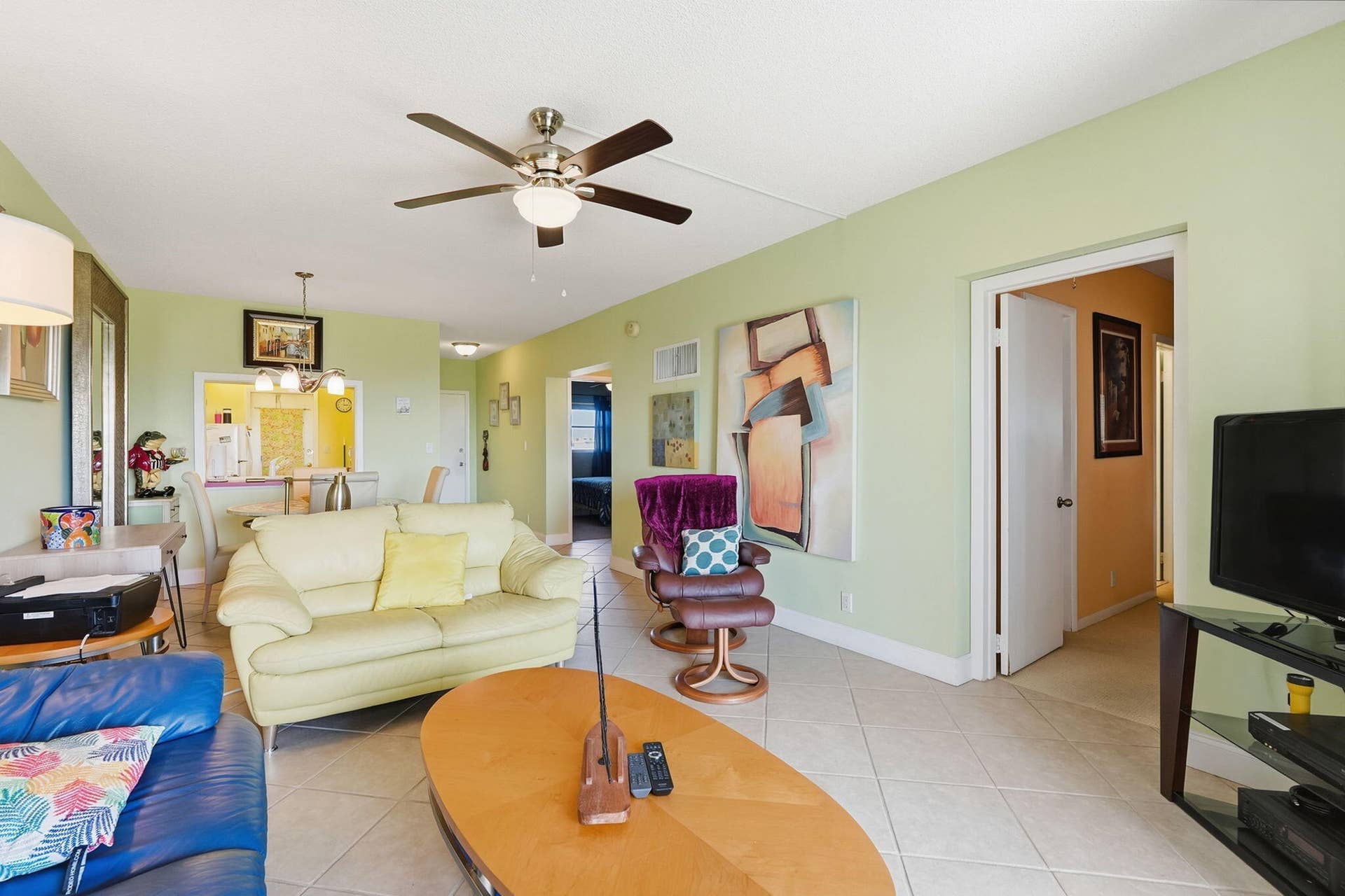 Open concept living and dining area featuring tile flooring, ceiling fan, pass-through window to kitchen, and recessed lighting
