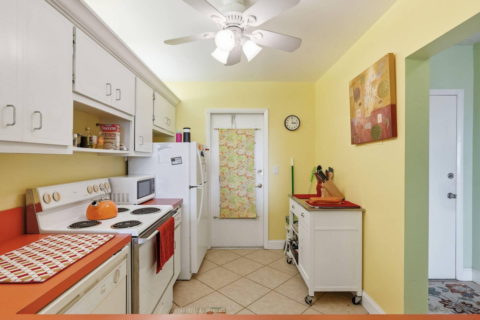 Kitchen featuring white cabinetry, orange countertops, tile flooring, and a ceiling fan