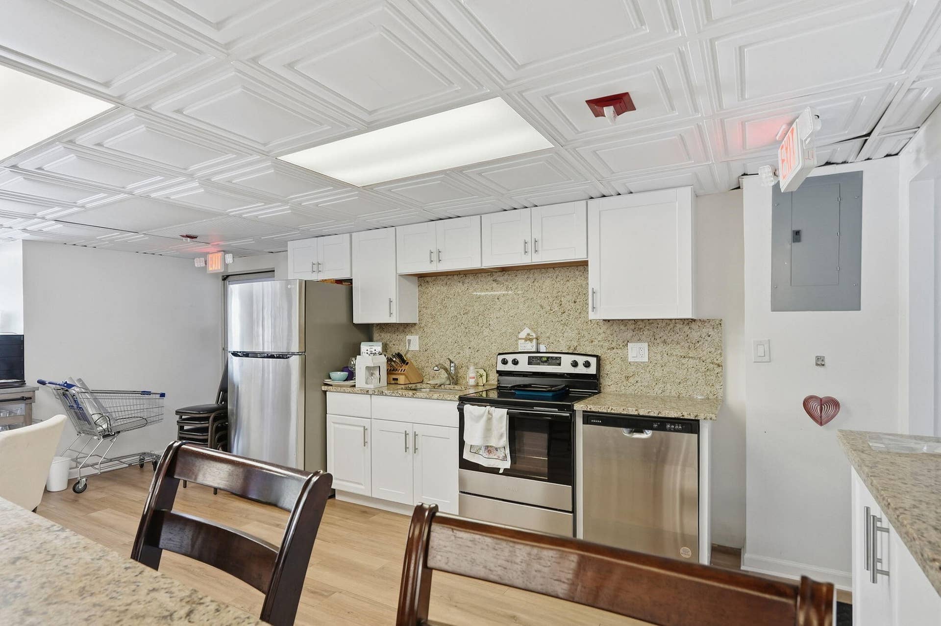 Kitchen area featuring white cabinetry, granite countertops, and stainless steel appliances