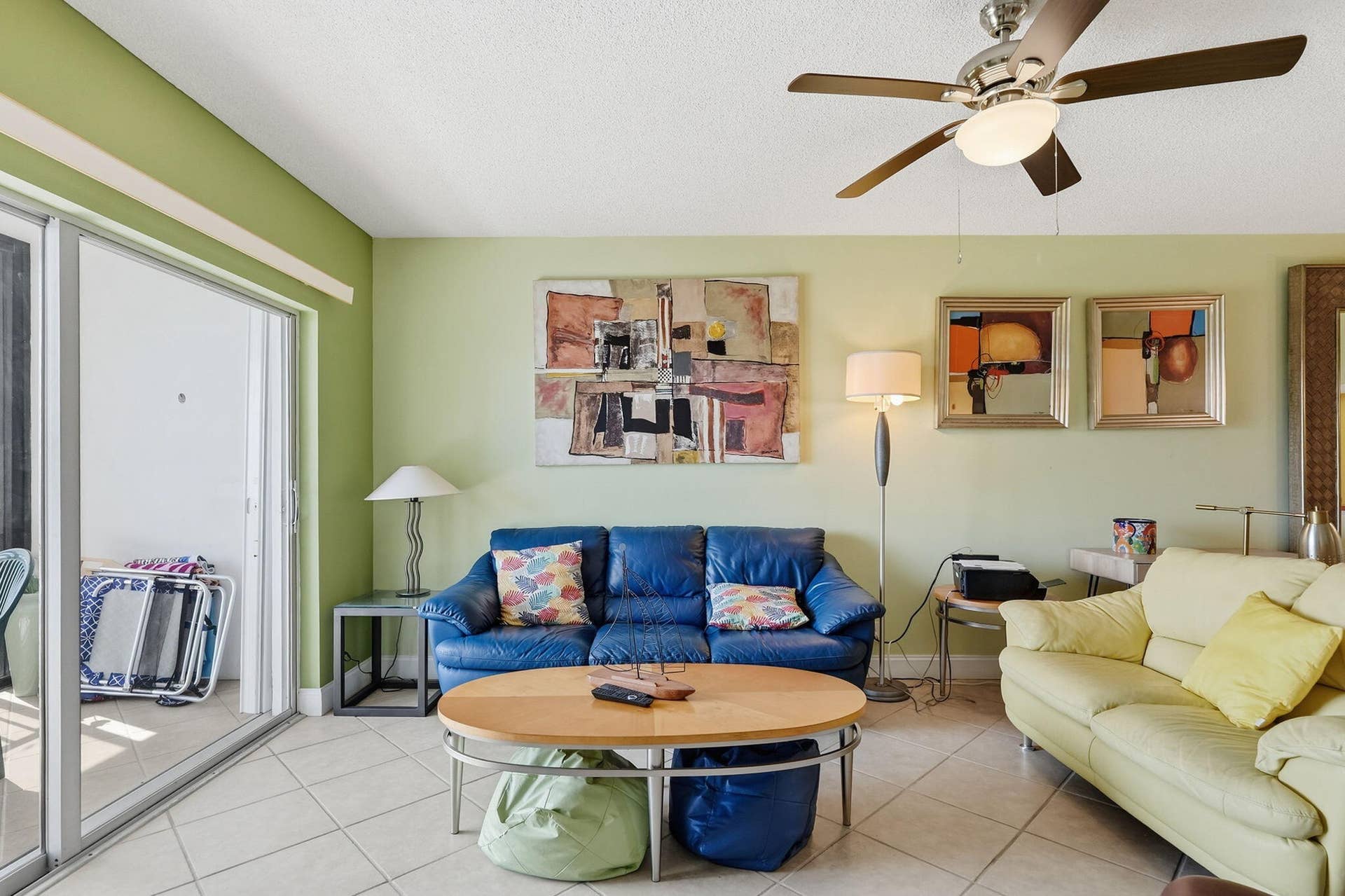 Tiled flooring, sliding glass door access to a balcony, ceiling fan with integrated lighting, recessed lighting, and painted walls