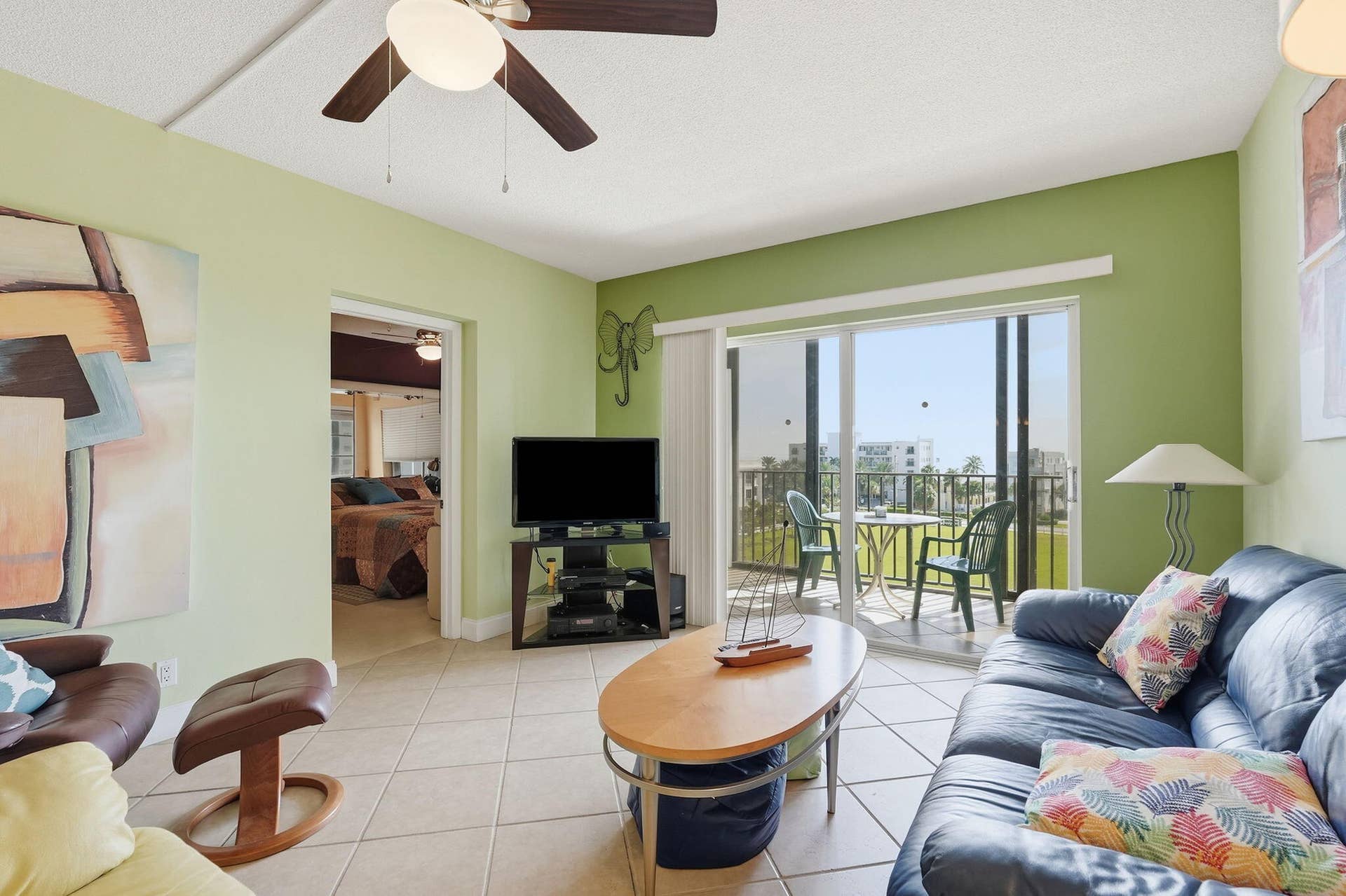 Tiled flooring, ceiling fan, sliding glass door, and balcony with metal railing