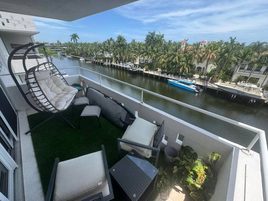 180 Isle Of Venice Drive, #433, Fort Lauderdale, FL 33301 Balcony with water frontage featuring a white railing, artificial turf flooring, and a sliding glass door