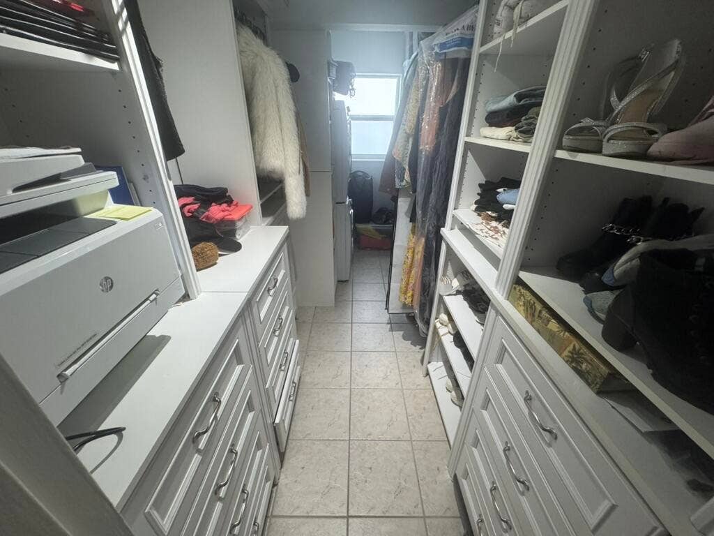 180 Isle Of Venice Drive, #433, Fort Lauderdale, FL 33301 Custom closet system featuring built-in shelving, multiple drawers with decorative pulls, and tile flooring