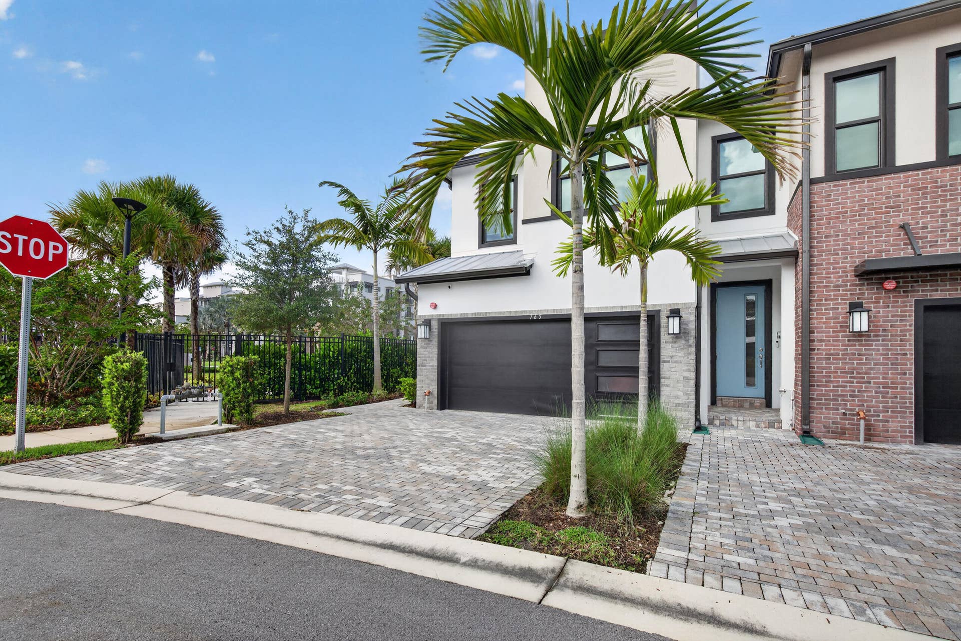 765 NW 84TH Terrace, Plantation, FL 33324 Modern exterior design with a paver driveway, an attached garage, and a light blue entry door