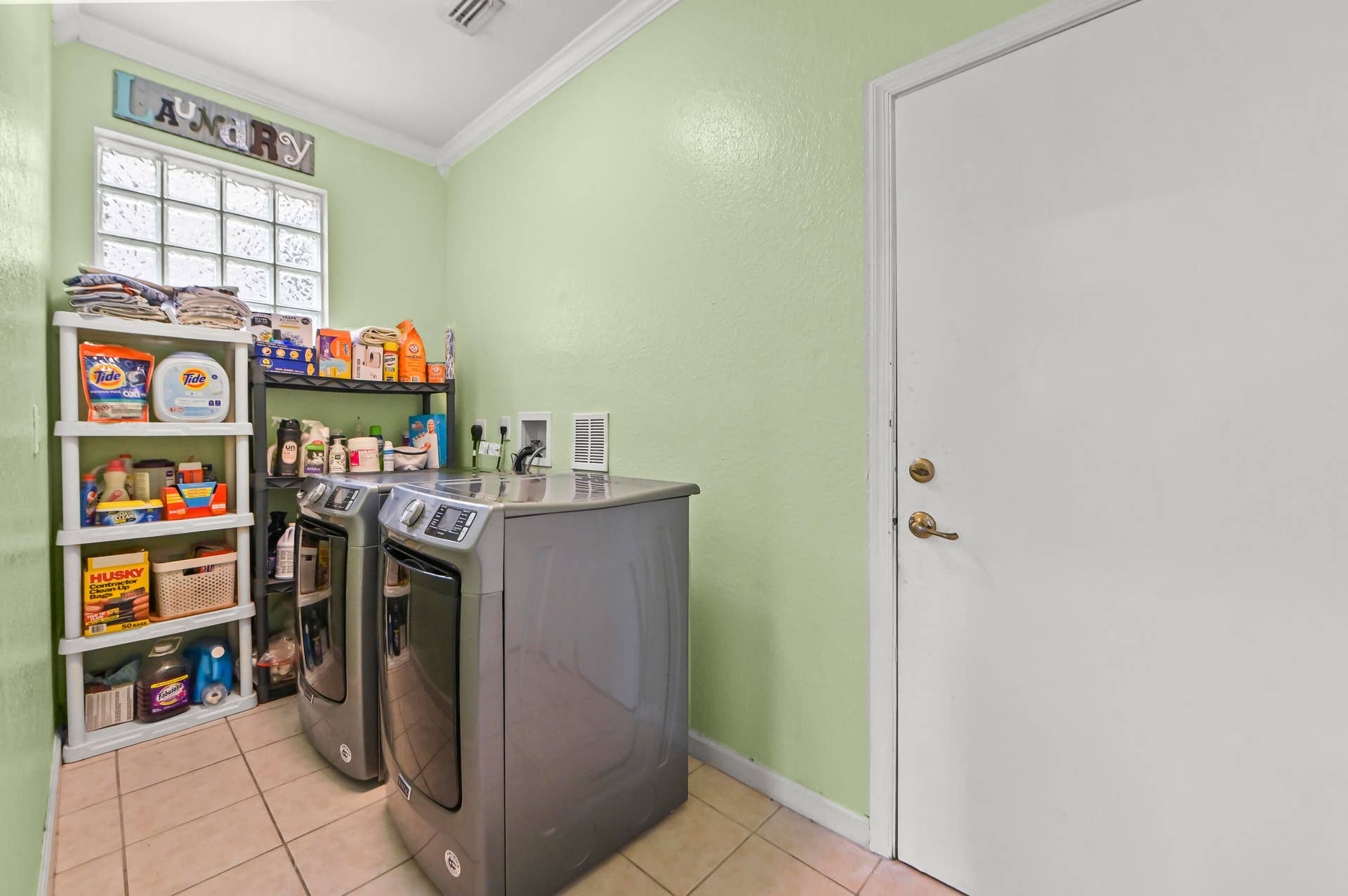 Ceramic tile flooring, crown molding, and a glass block window