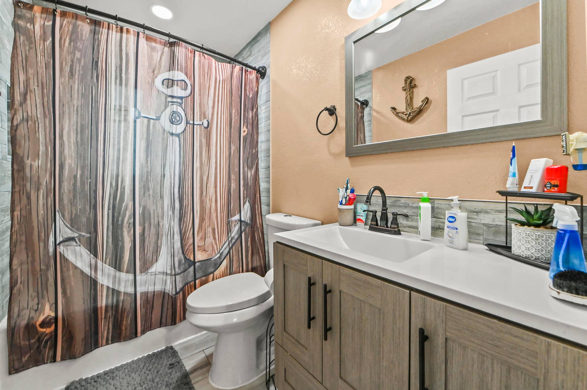 Modern vanity with integrated sink, wood-finish cabinetry, and matte black faucet