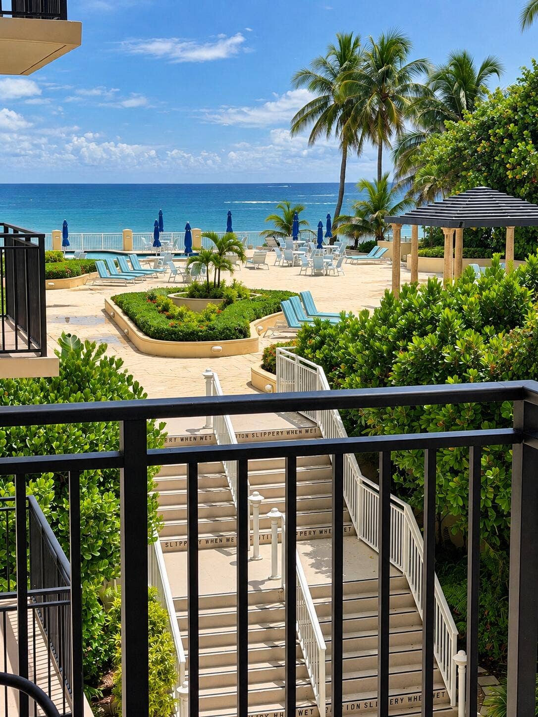 3475 S OCEAN Boulevard, #2050, Palm Beach, FL 33480 Expansive outdoor common area with ocean frontage, multiple seating areas, a shaded gazebo, and direct access stairs