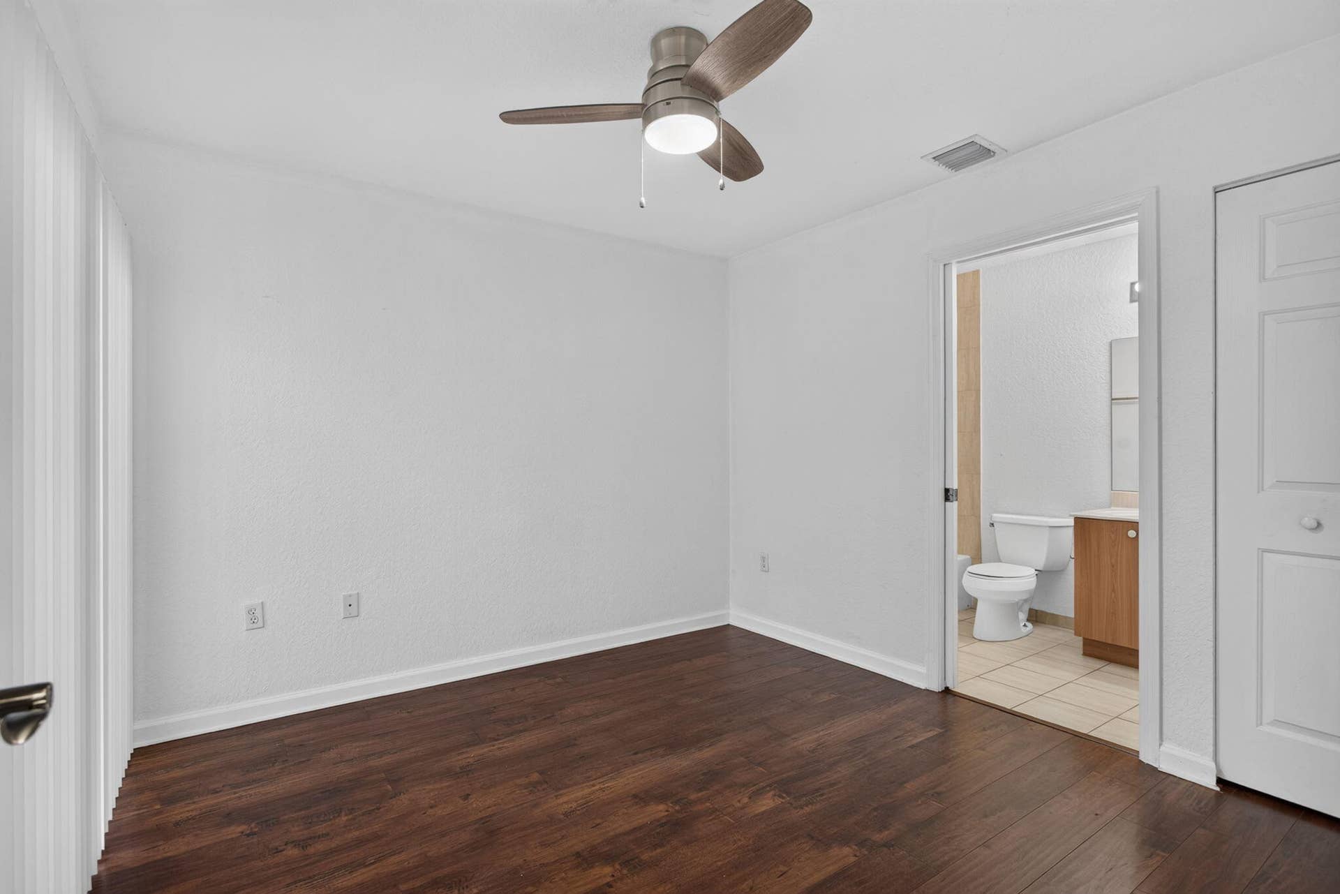 2725 NE 8TH Avenue, #112, Wilton Manors, FL 33334 Wood-finish flooring, ceiling fan, white wall paint, white trim, and a white paneled door