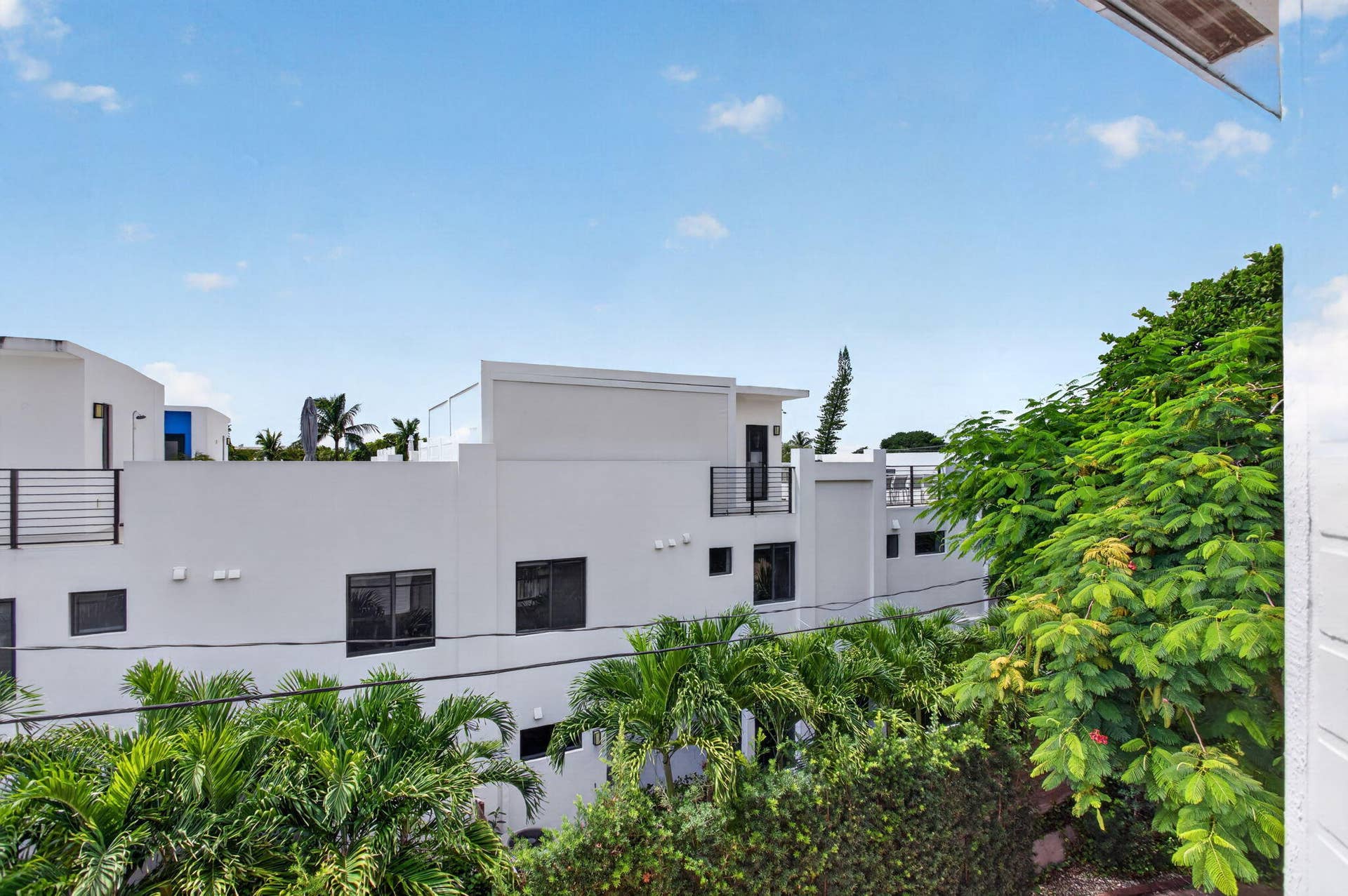 2725 NE 8TH Avenue, #112, Wilton Manors, FL 33334 Contemporary multi-level exterior with flat rooflines, dark-framed windows, and multiple balconies with metal railings