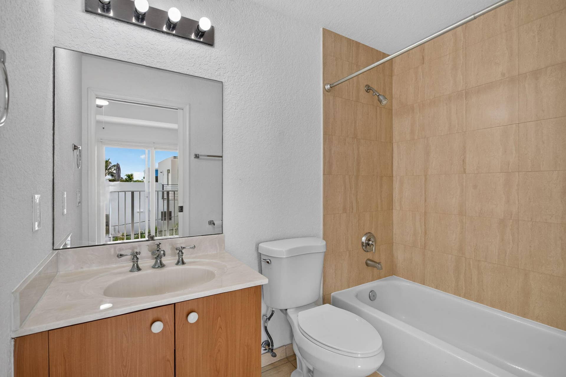 2725 NE 8TH Avenue, #112, Wilton Manors, FL 33334 Bathroom featuring a vanity with a light-toned countertop, integrated sink, wood-finish cabinetry, and a full-width mirror
