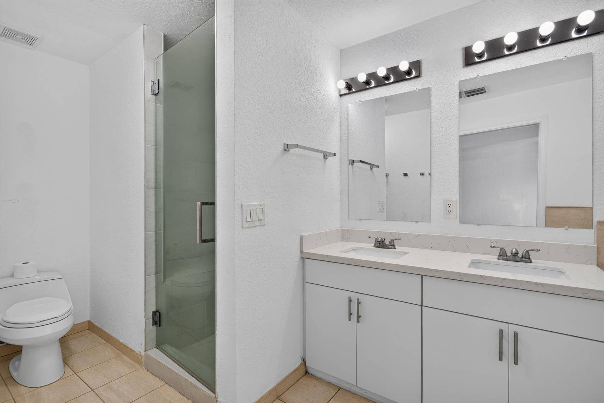 2725 NE 8TH Avenue, #112, Wilton Manors, FL 33334 Dual vanity with rectangular undermount sinks, stone countertops, and overhead light fixtures