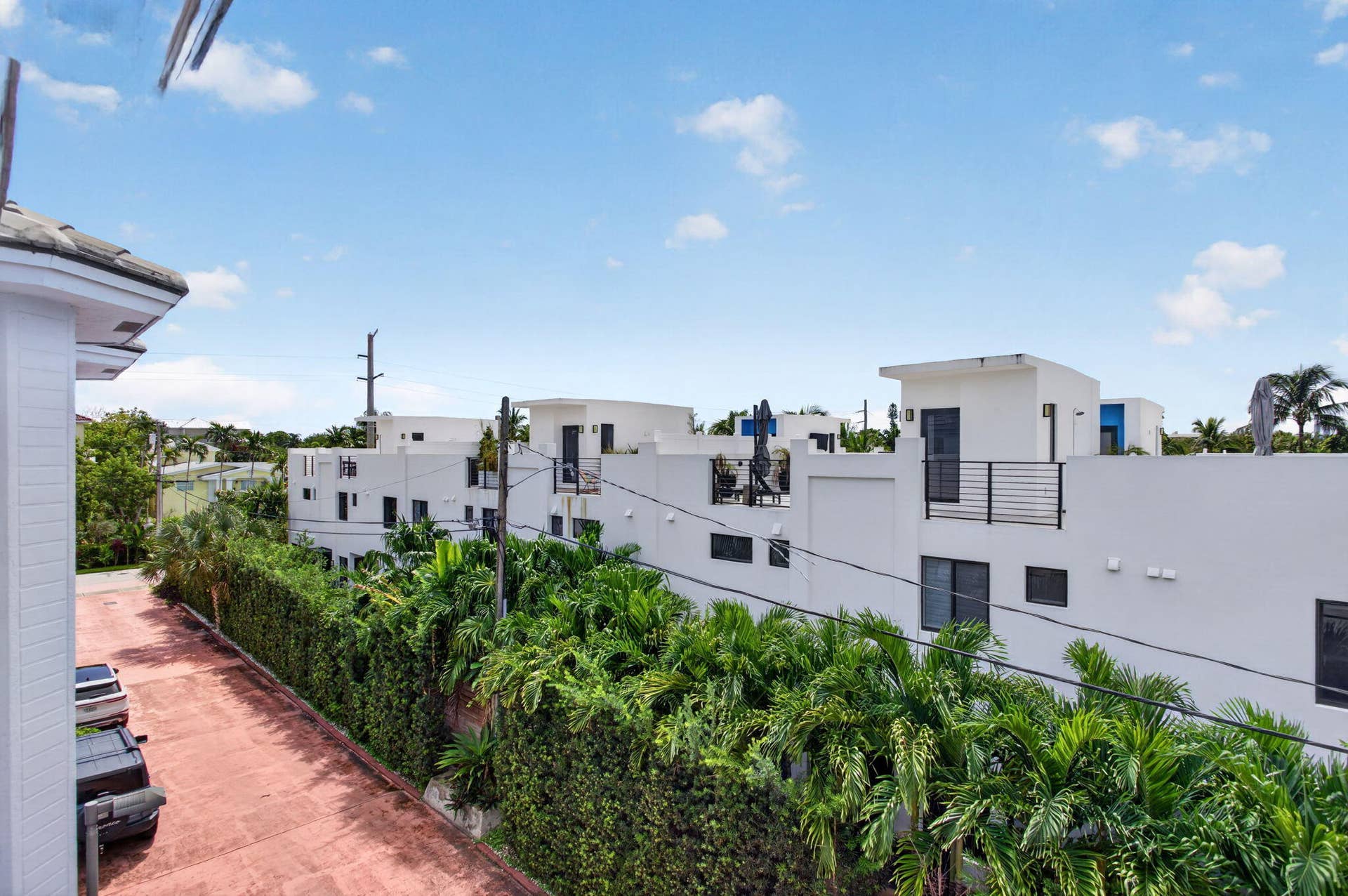 2725 NE 8TH Avenue, #112, Wilton Manors, FL 33334 Paved driveway with ample parking, bordered by dense green foliage