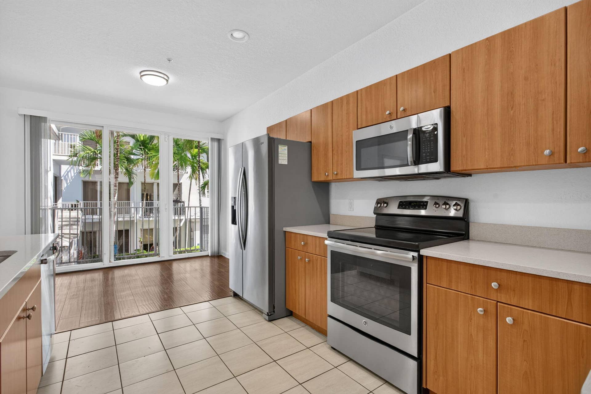 2725 NE 8TH Avenue, #112, Wilton Manors, FL 33334 Kitchen featuring wood-finish cabinetry, stainless steel appliances, and light-toned countertops