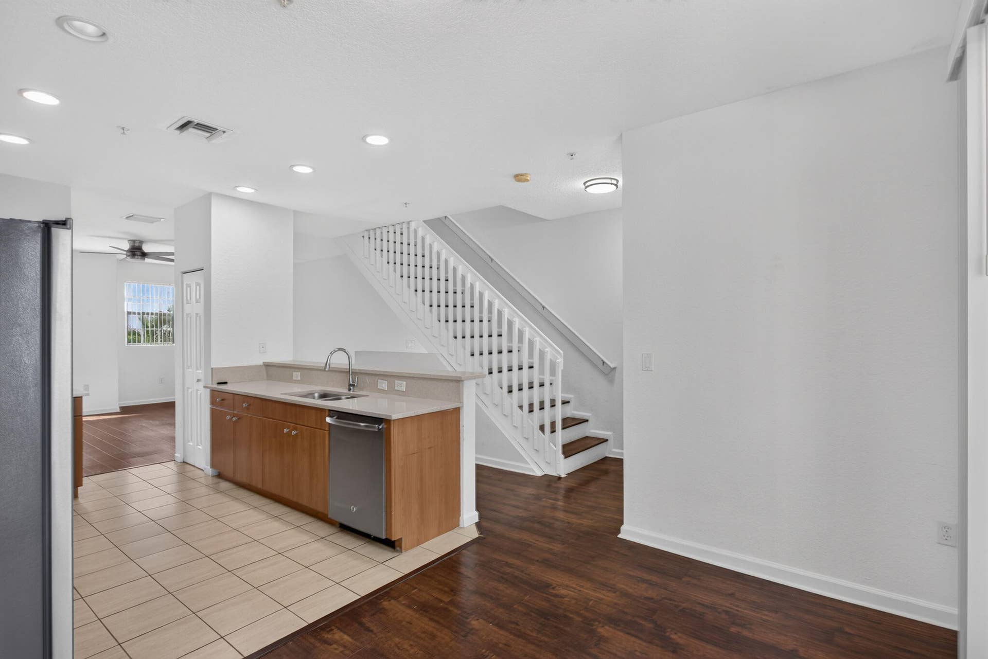 2725 NE 8TH Avenue, #112, Wilton Manors, FL 33334 Kitchen with wood-finish cabinetry, stainless steel dishwasher, and light-toned countertops