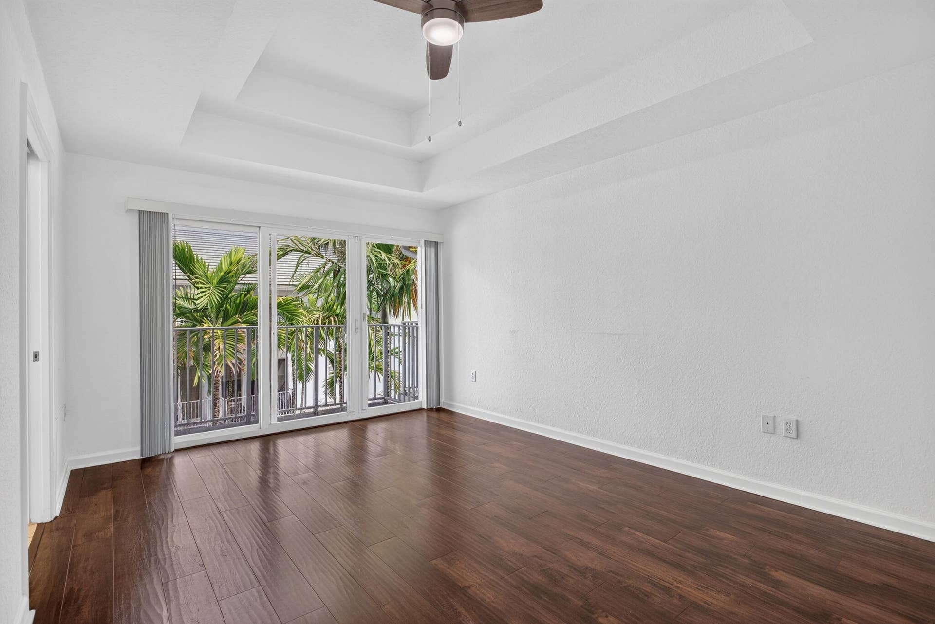 2725 NE 8TH Avenue, #112, Wilton Manors, FL 33334 Dark wood-finish flooring with a tray ceiling and ceiling fan