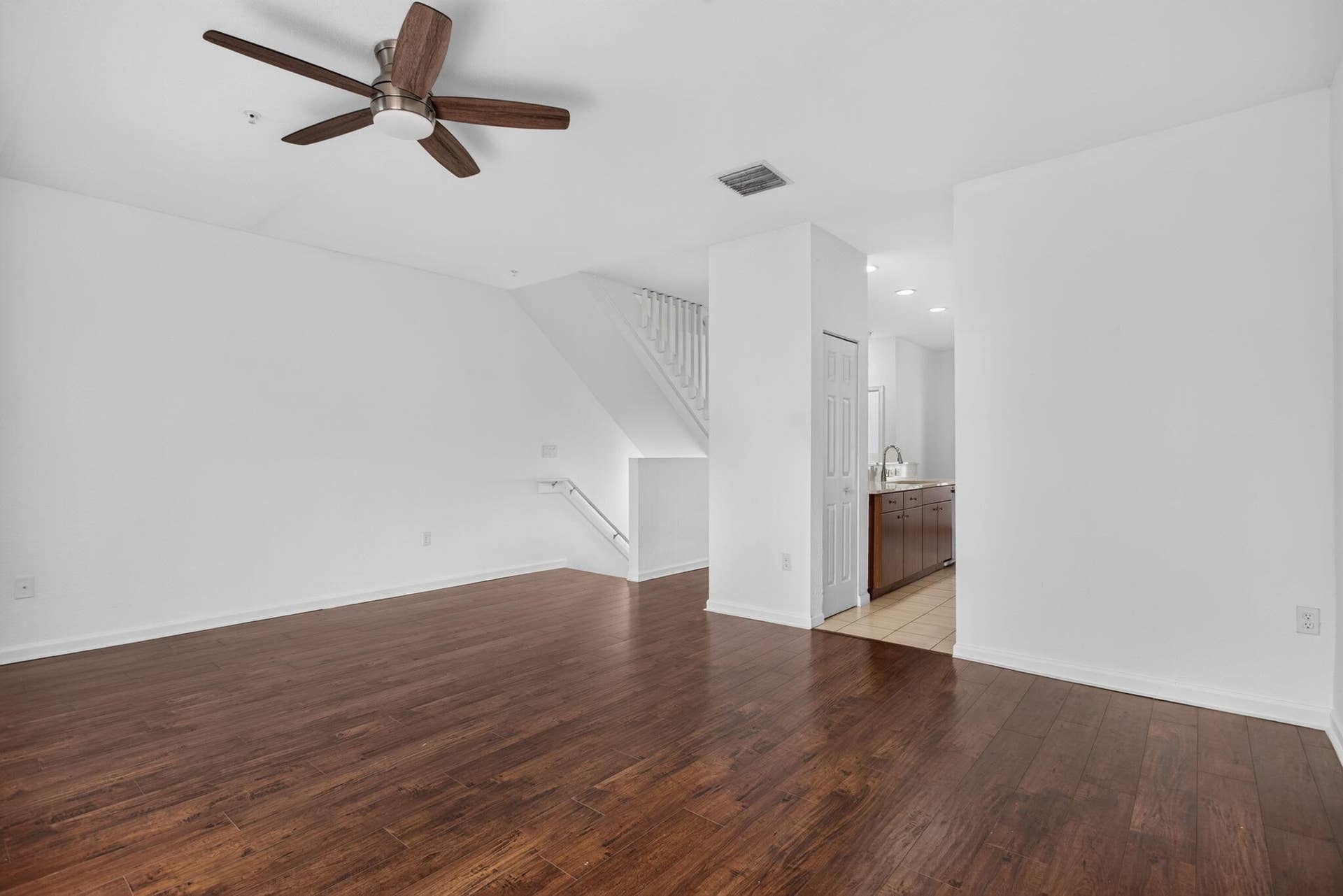 2725 NE 8TH Avenue, #112, Wilton Manors, FL 33334 Wood-finish flooring throughout, white painted walls, and a ceiling fan with integrated lighting