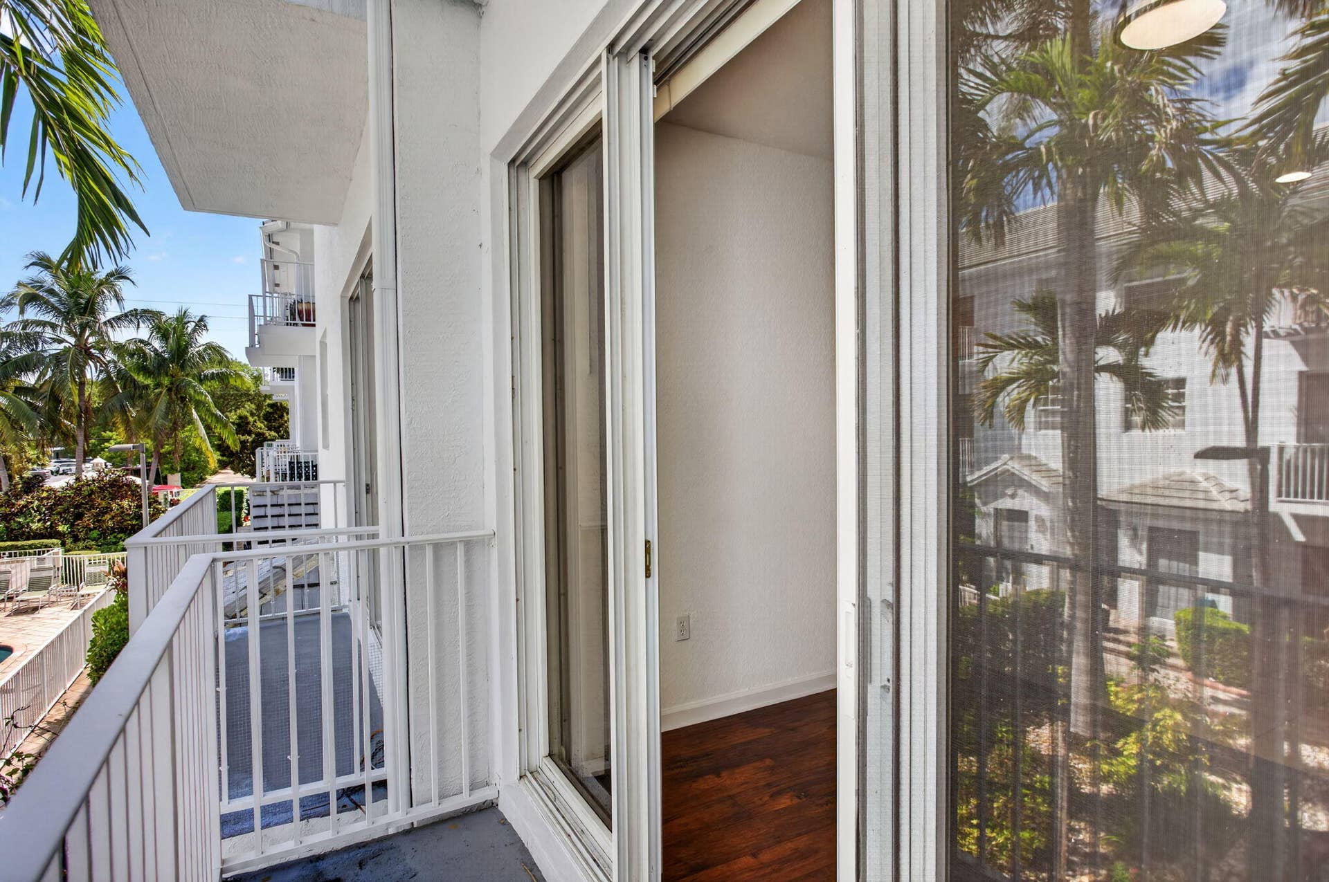 2725 NE 8TH Avenue, #112, Wilton Manors, FL 33334 Sliding glass door access to a private balcony with white railing