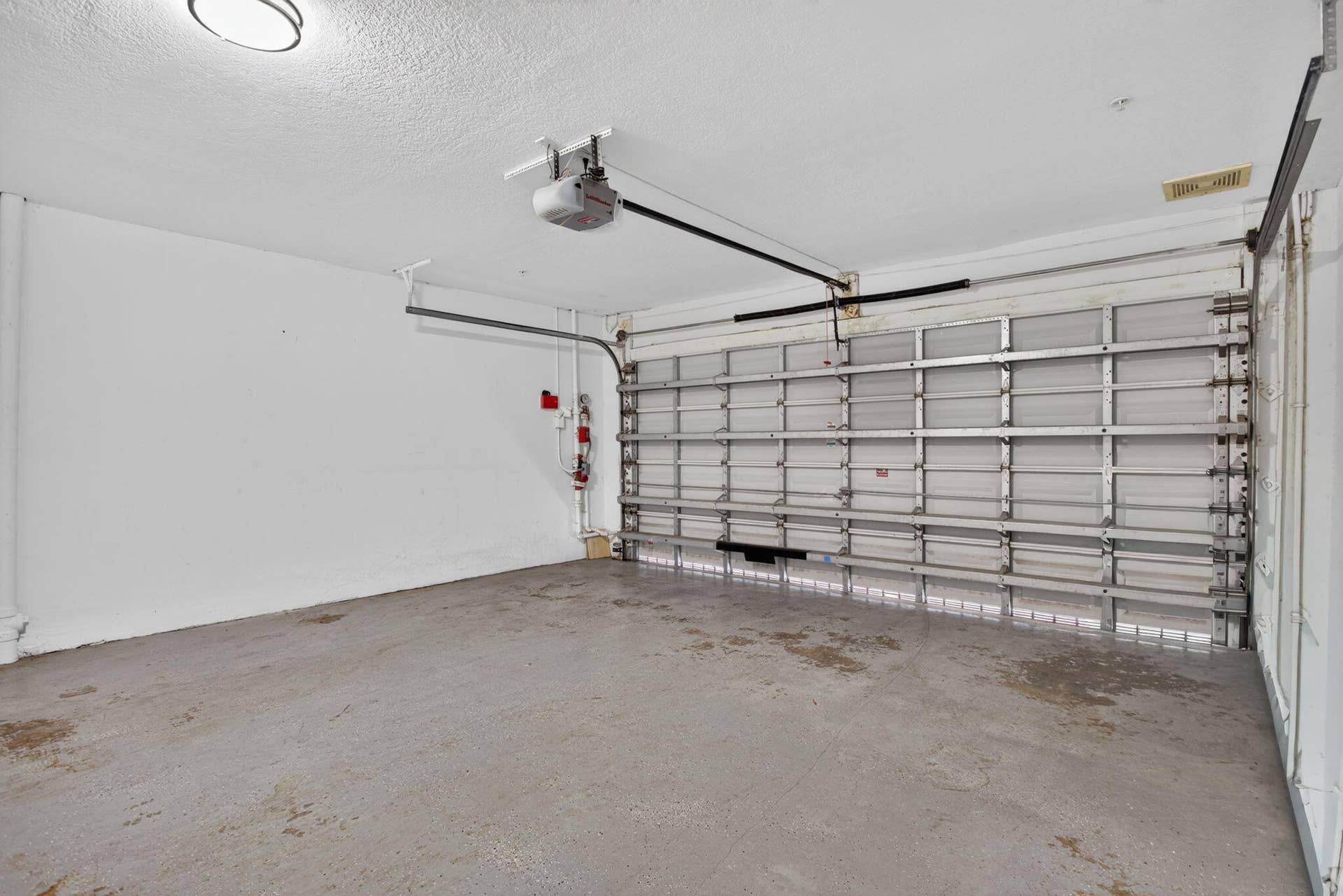 2725 NE 8TH Avenue, #112, Wilton Manors, FL 33334 Garage with automatic overhead door opener and concrete flooring