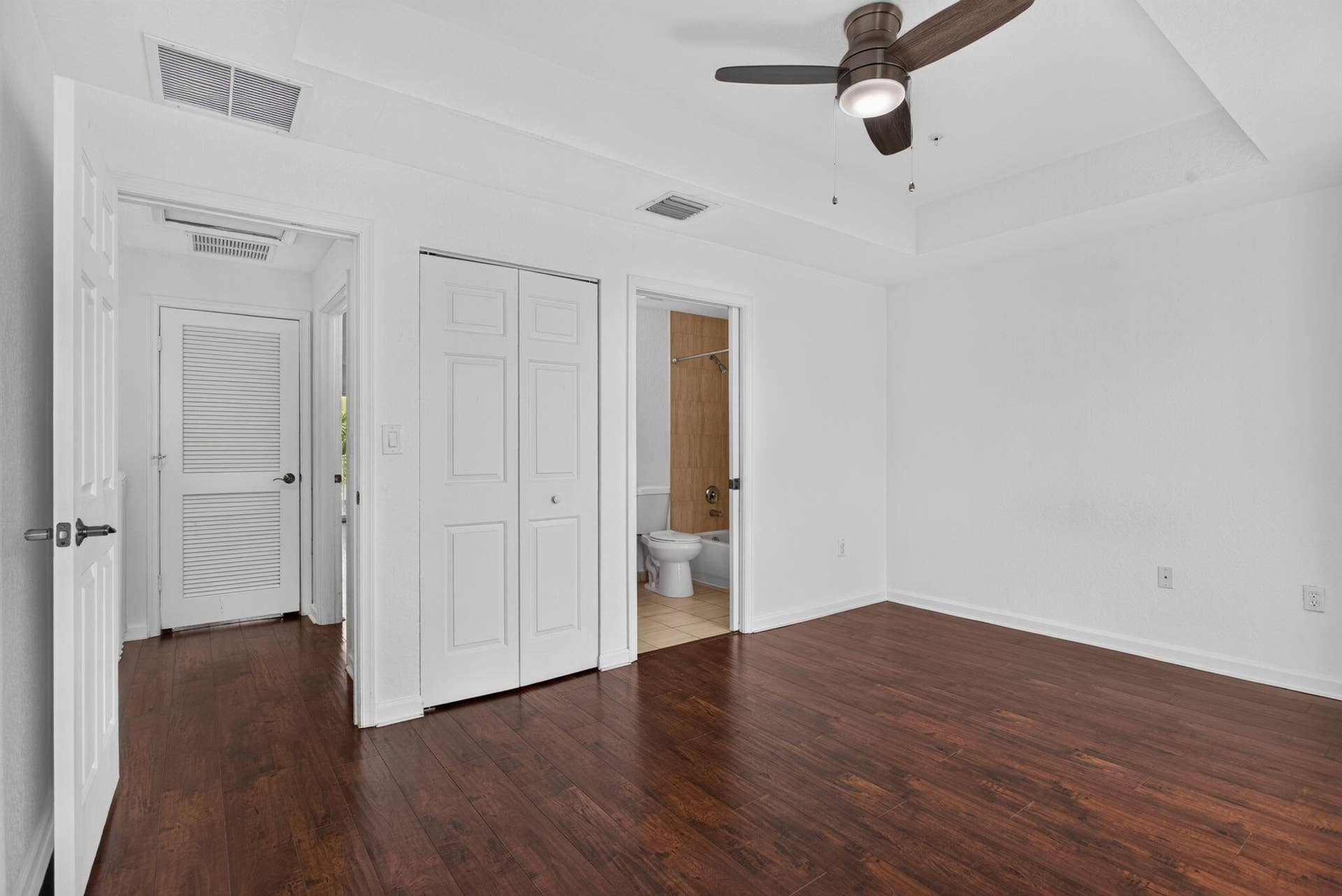 2725 NE 8TH Avenue, #112, Wilton Manors, FL 33334 Room featuring wood-finish flooring, a ceiling fan, and tray ceiling