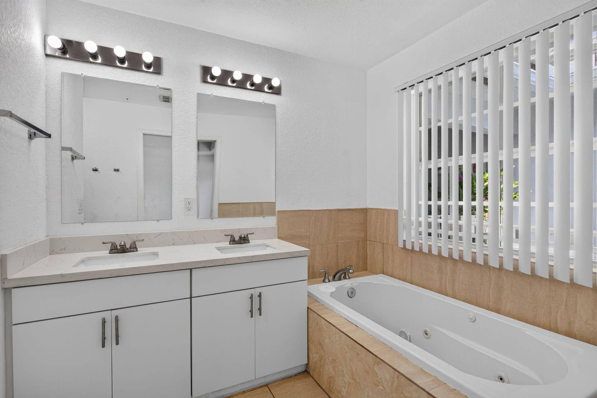 2725 NE 8TH Avenue, #112, Wilton Manors, FL 33334 Dual vanity with undermount sinks, white cabinetry, and a light-toned countertop