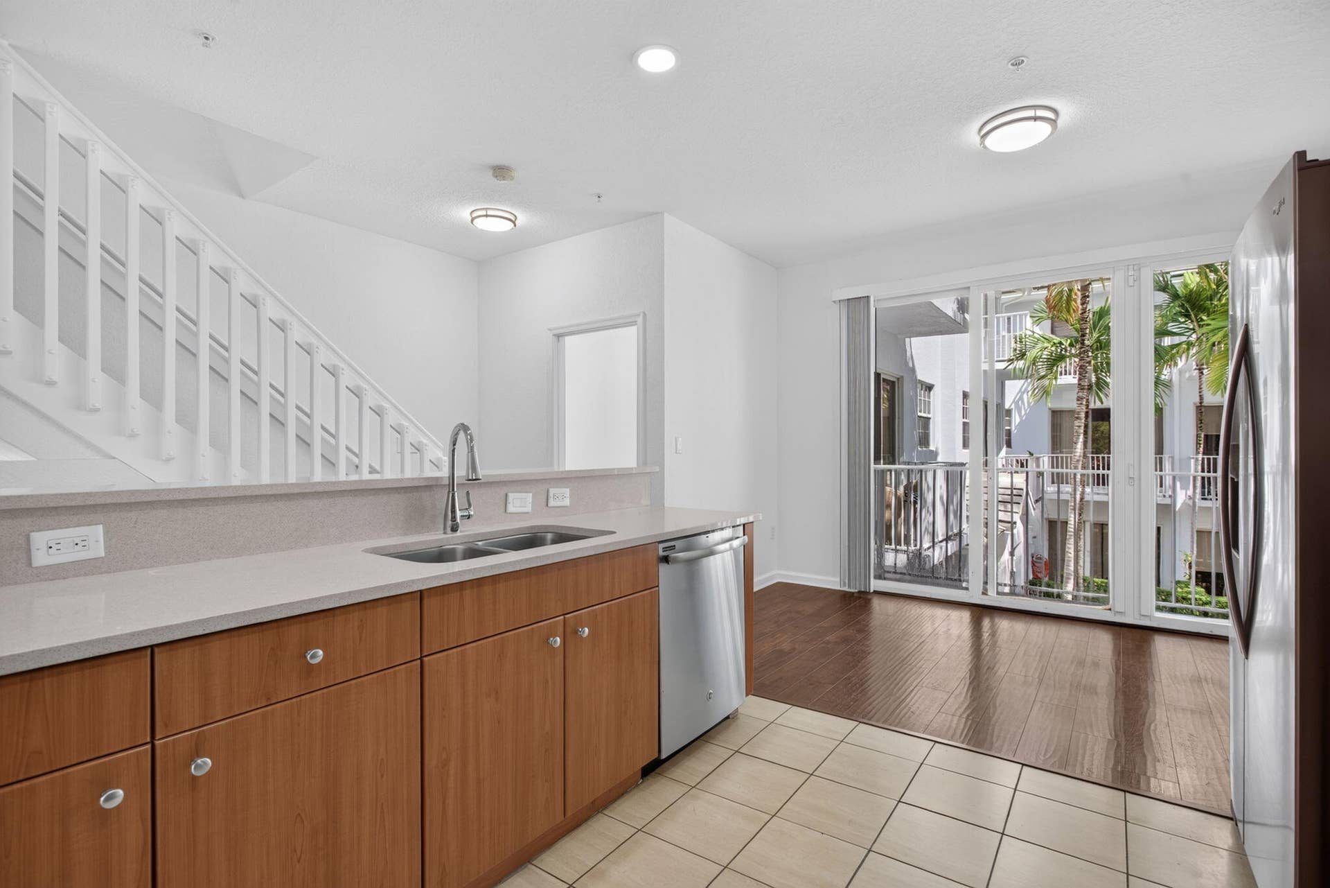 2725 NE 8TH Avenue, #112, Wilton Manors, FL 33334 Kitchen featuring a double basin sink, light-toned countertops, and wood-finish cabinetry