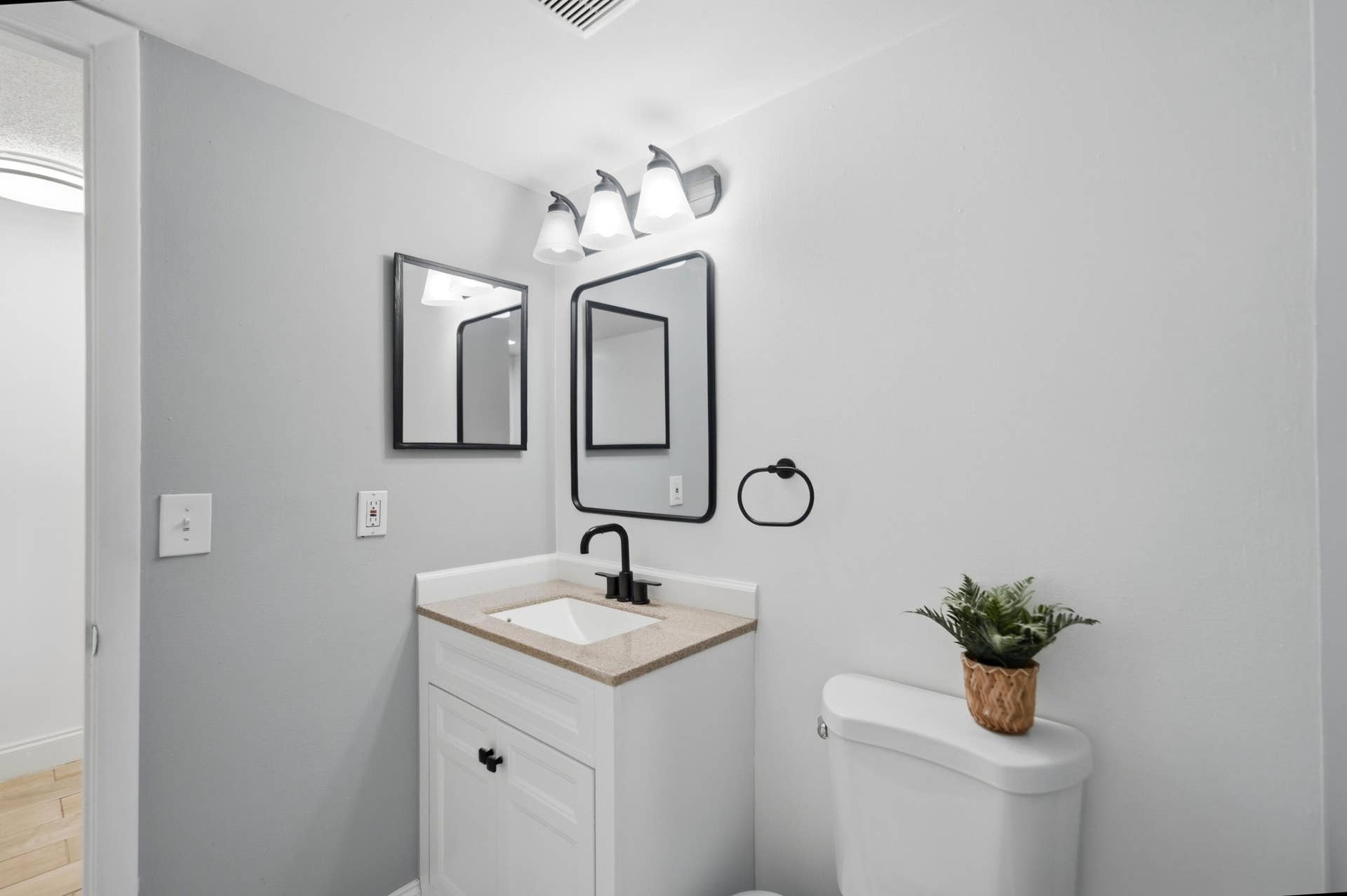 White vanity with a neutral-toned countertop and an undermount sink