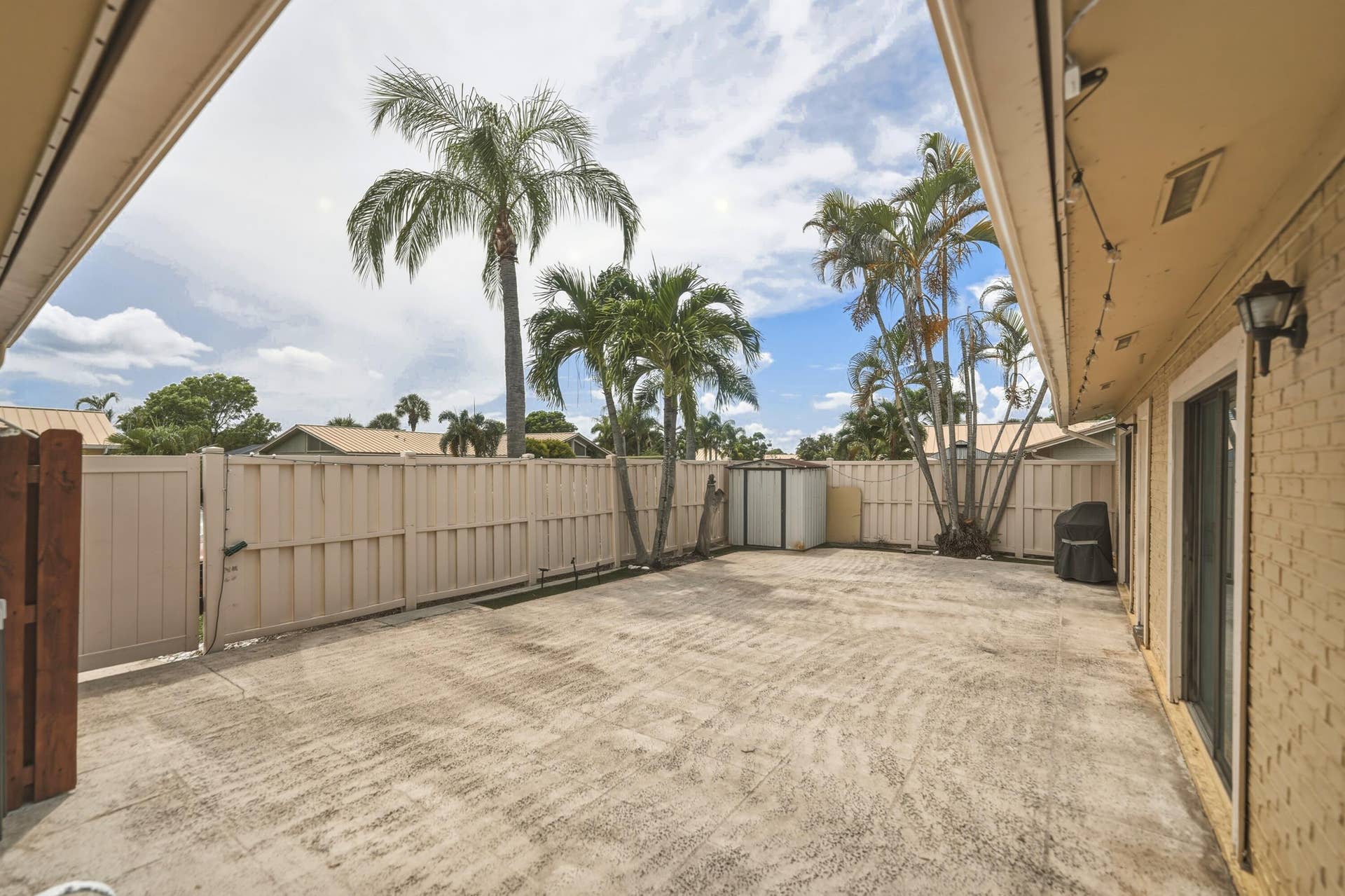Expansive concrete patio with perimeter fencing and a gate