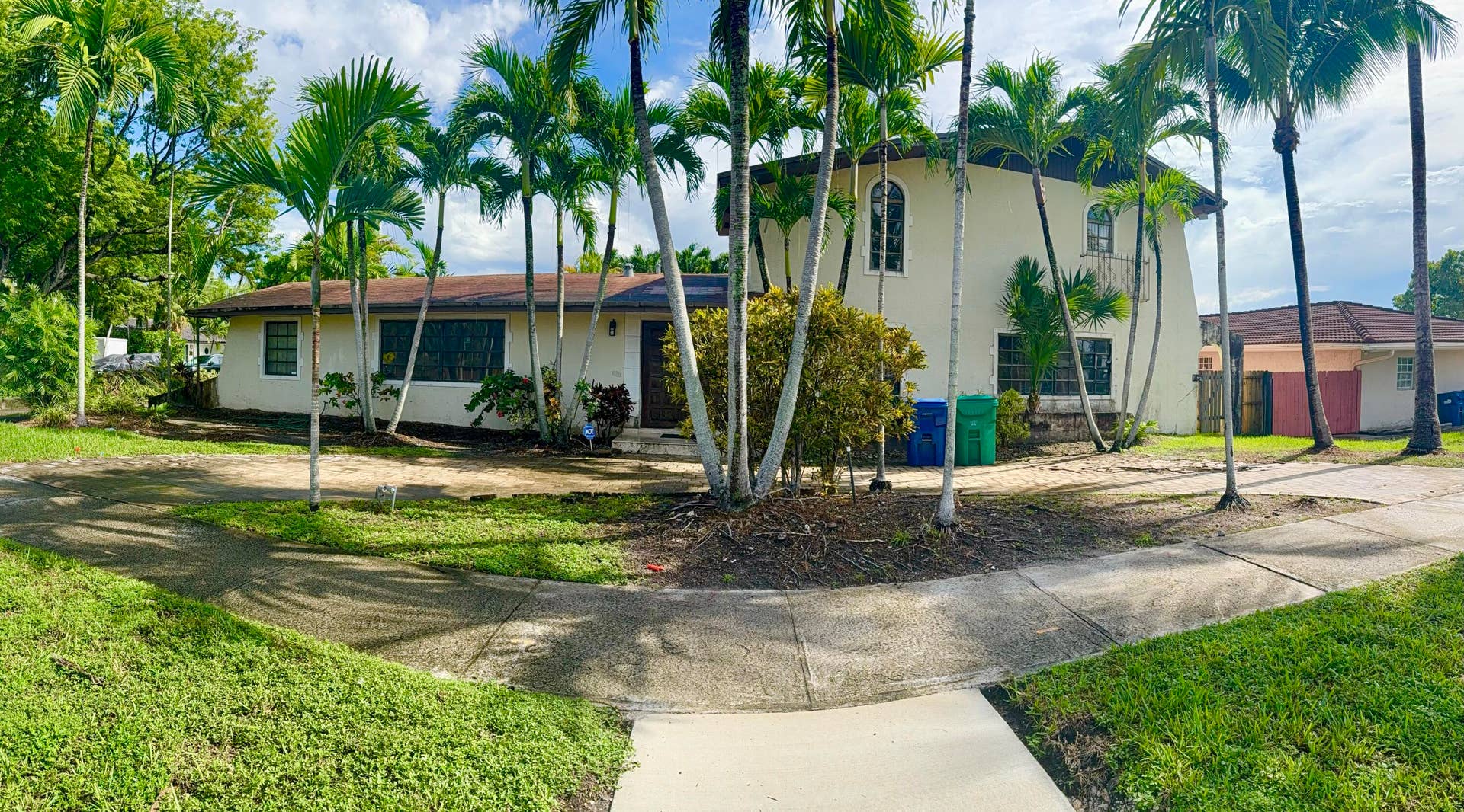2390 NE 199th Street, Aventura, FL 33180 Two-story stucco exterior with arched windows, a single-story wing, and mature palm trees