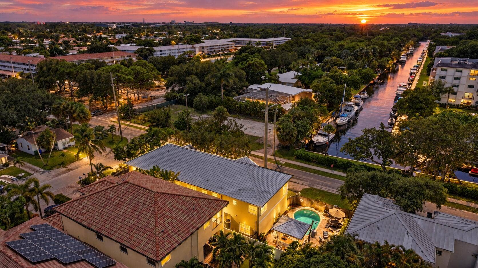 Aerial perspective showcasing waterfront properties, a private swimming pool, and a tile roof