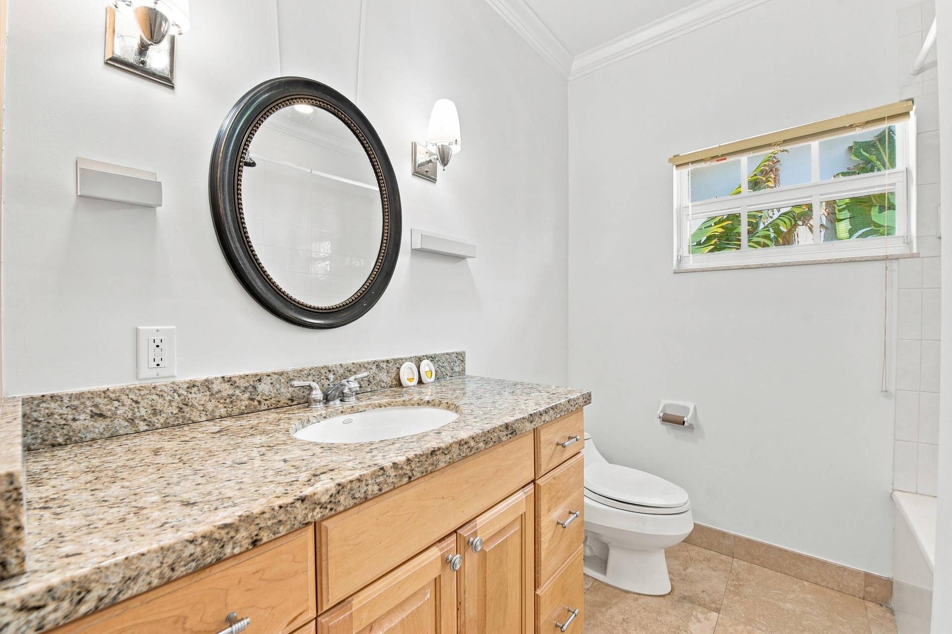 Spa-inspired bathroom featuring a wood-finish vanity with ample storage, granite-topped countertop, and an undermount sink
