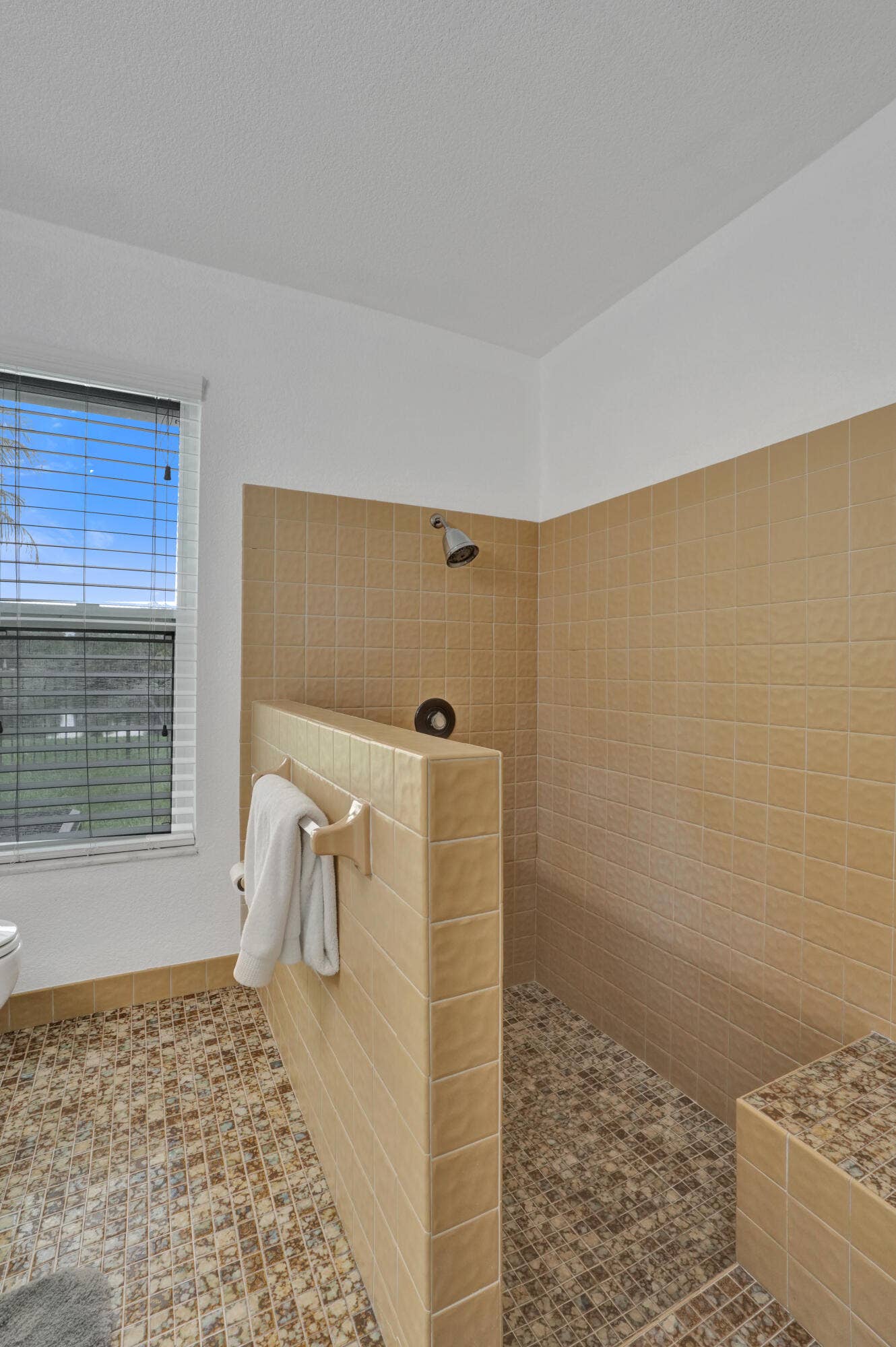 12072 NW 27TH Drive, Coral Springs, FL 33065 Walk-in shower with full height tile walls, tiled shower floor, and a built-in tiled bench