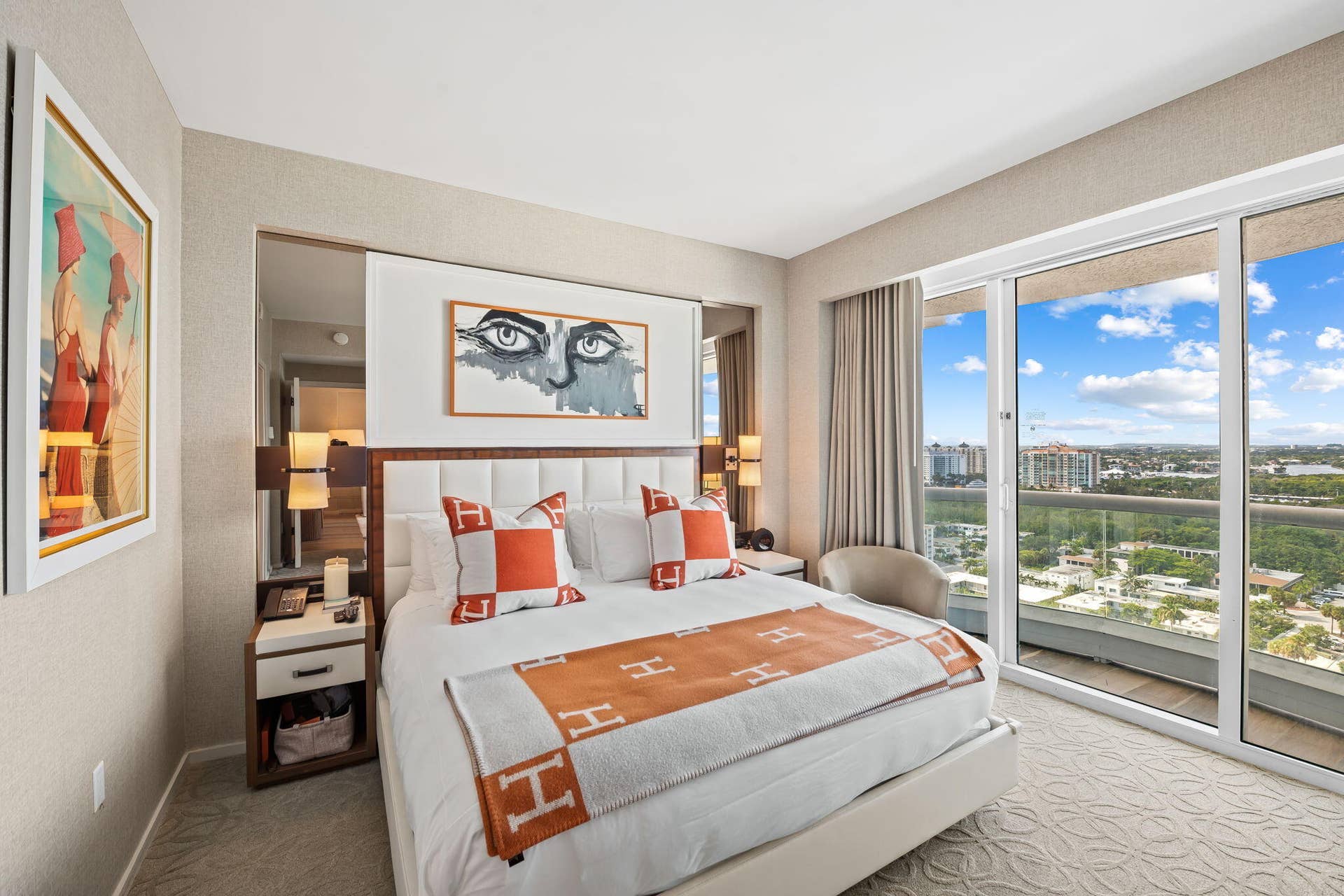 551 N FORT LAUDERDALE BEACH Boulevard, #R1801, Fort Lauderdale, FL 33304 Sliding glass doors with balcony access, upholstered headboard, built-in bedside tables with storage, wall-mounted lighting fixtures, and textured wall coverings
