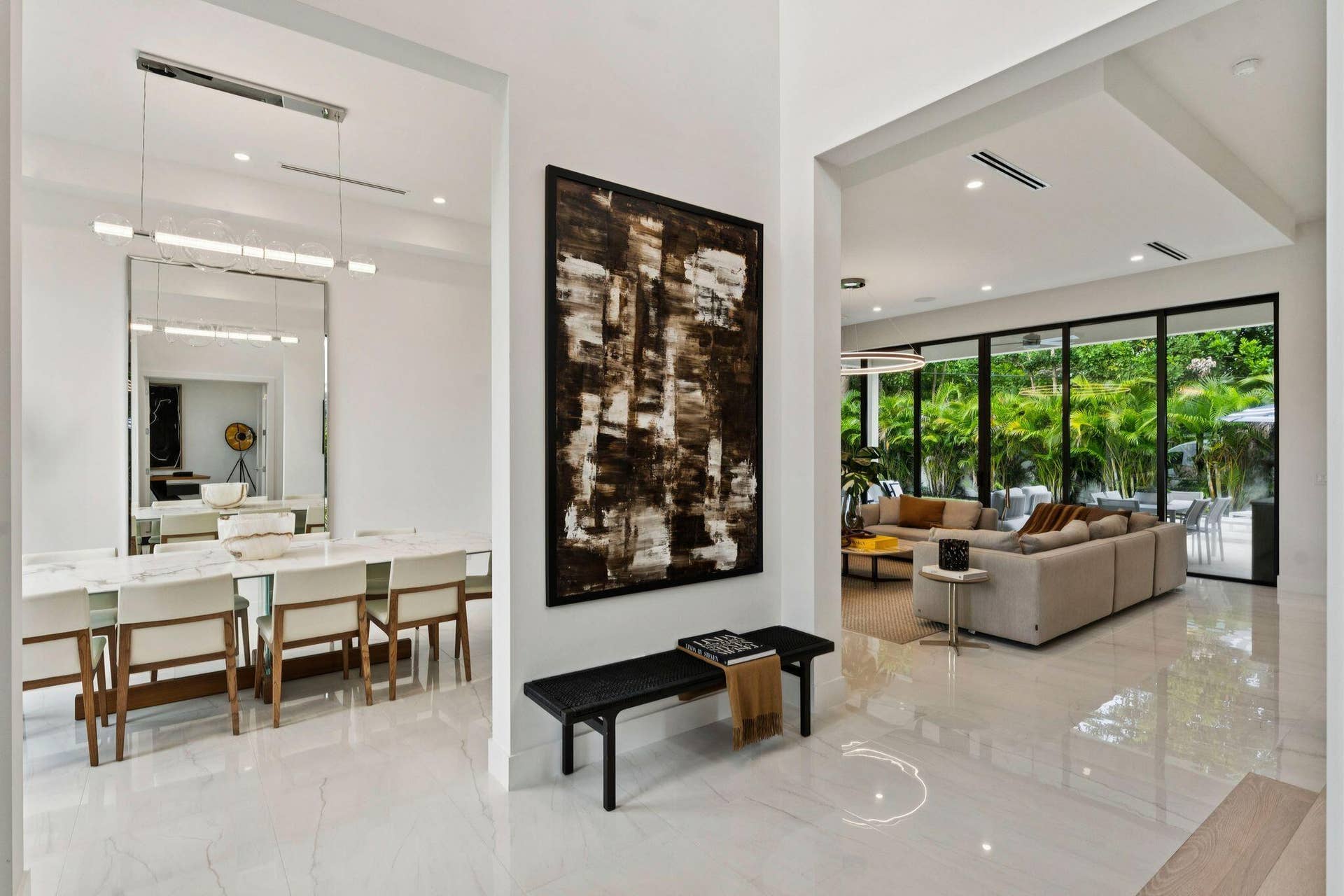 Open-concept interior featuring high ceilings, recessed lighting, expansive glass doors, and polished tile flooring