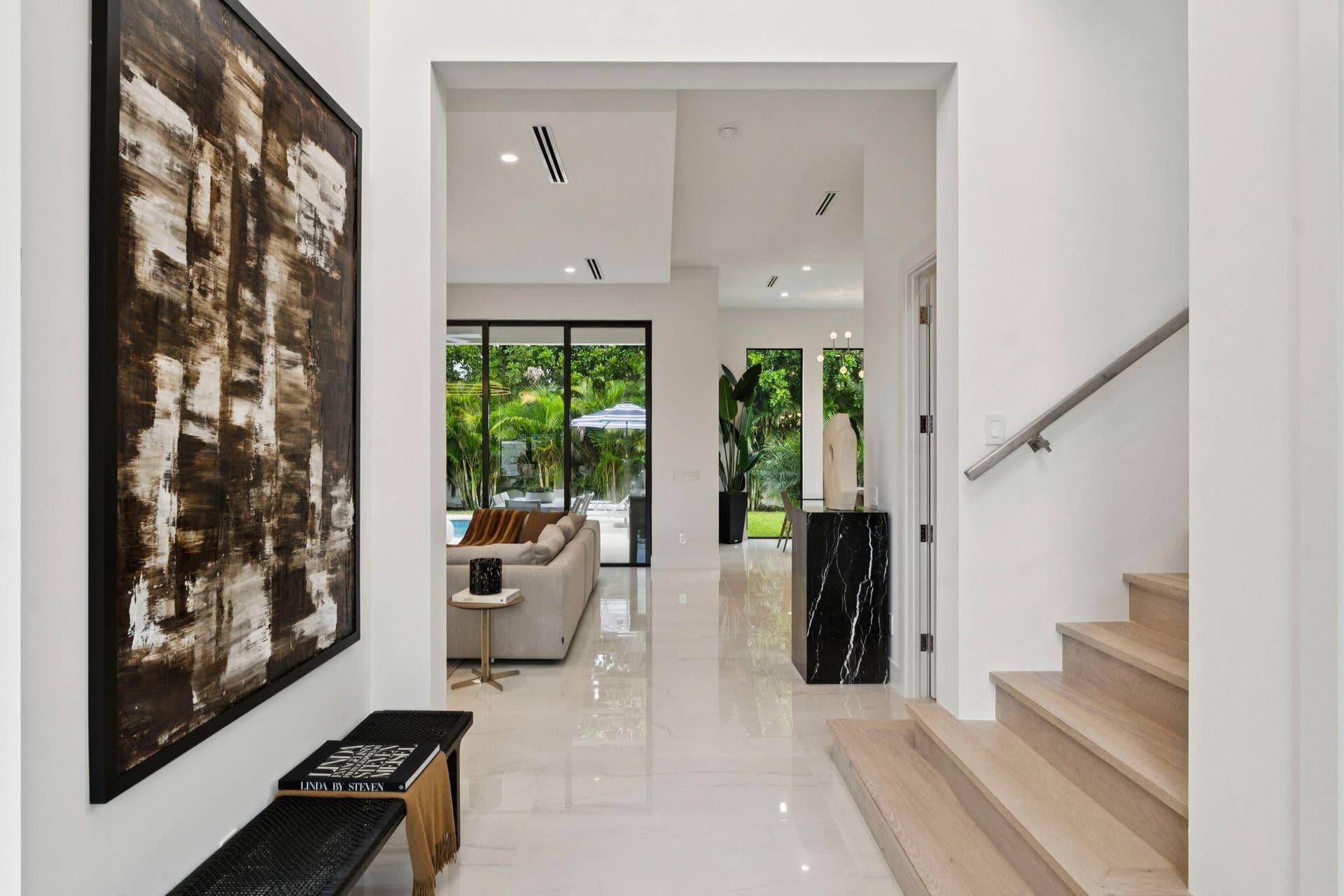 White tile flooring, recessed lighting, and a modern wood staircase with a metal handrail