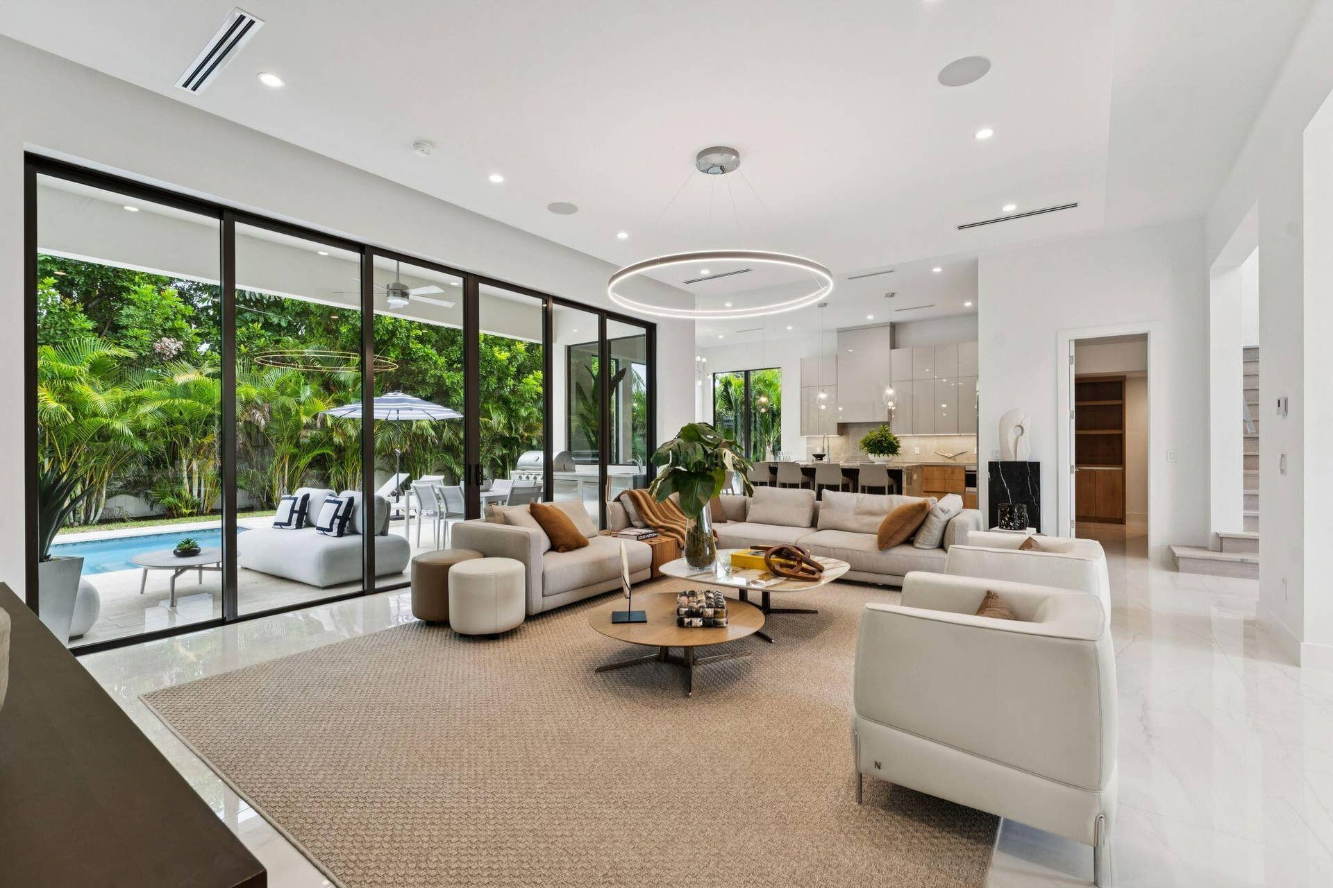Expansive living area with large format tile flooring and recessed lighting
