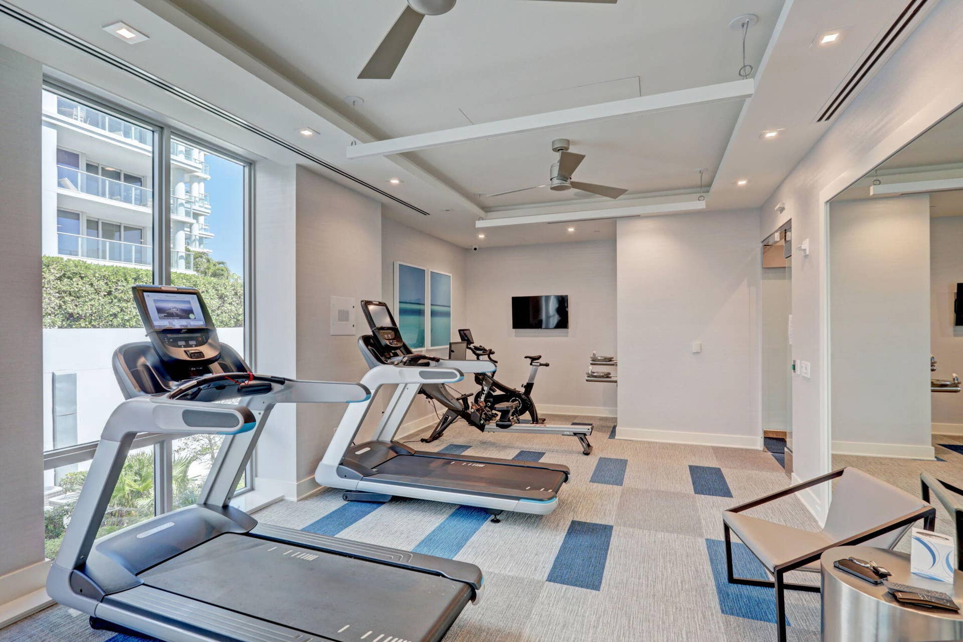 1 Water Club Way, #503, North Palm Beach, FL 33408 Floor-to-ceiling window, ceiling fans, recessed lighting, wall-mounted television, and patterned carpet flooring
