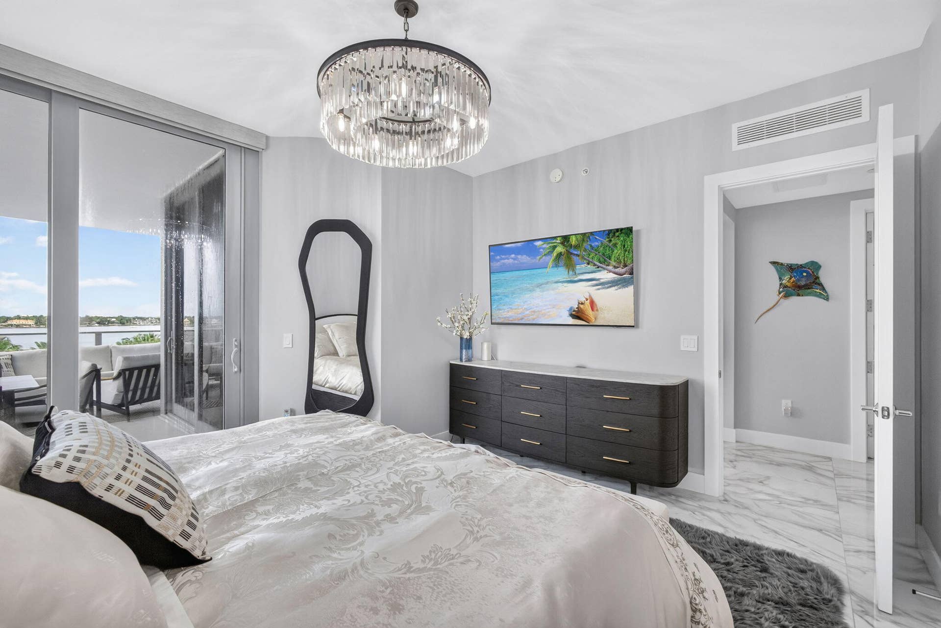 1 Water Club Way, #503, North Palm Beach, FL 33408 Sliding glass doors to outdoor balcony, crystal chandelier, built-in dresser, and marble-look flooring