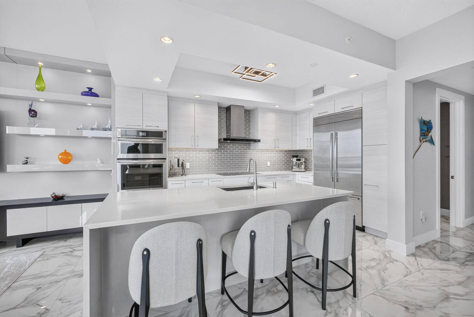 1 Water Club Way, #503, North Palm Beach, FL 33408 Pull up a stool and have a seat at this center island with integrated sink, stainless steel appliances, white cabinetry, and recessed lighting..not to mention the view!