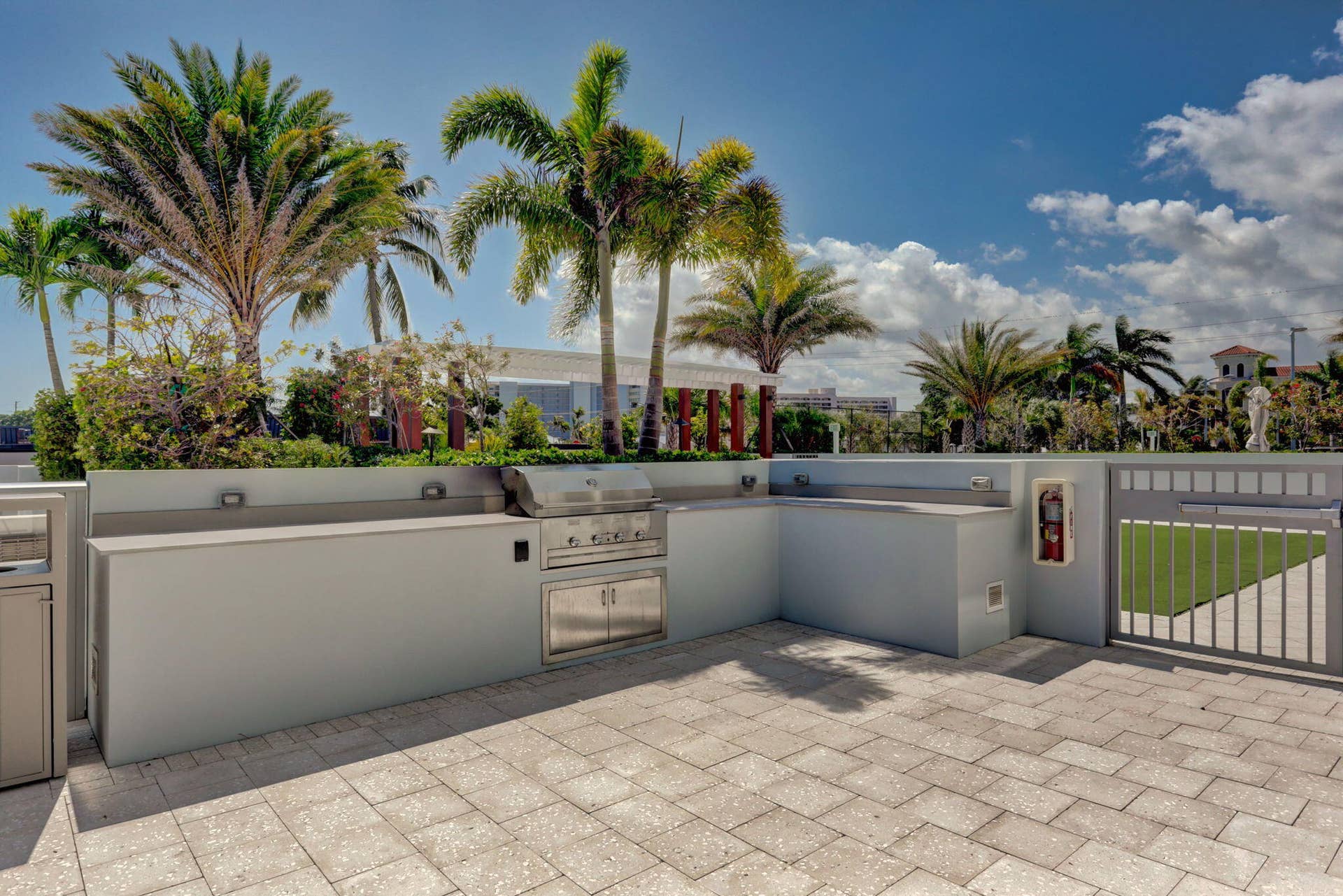 1 Water Club Way, #503, North Palm Beach, FL 33408 Paver patio featuring an outdoor kitchen with built-in grill, integrated cabinetry, and perimeter wall