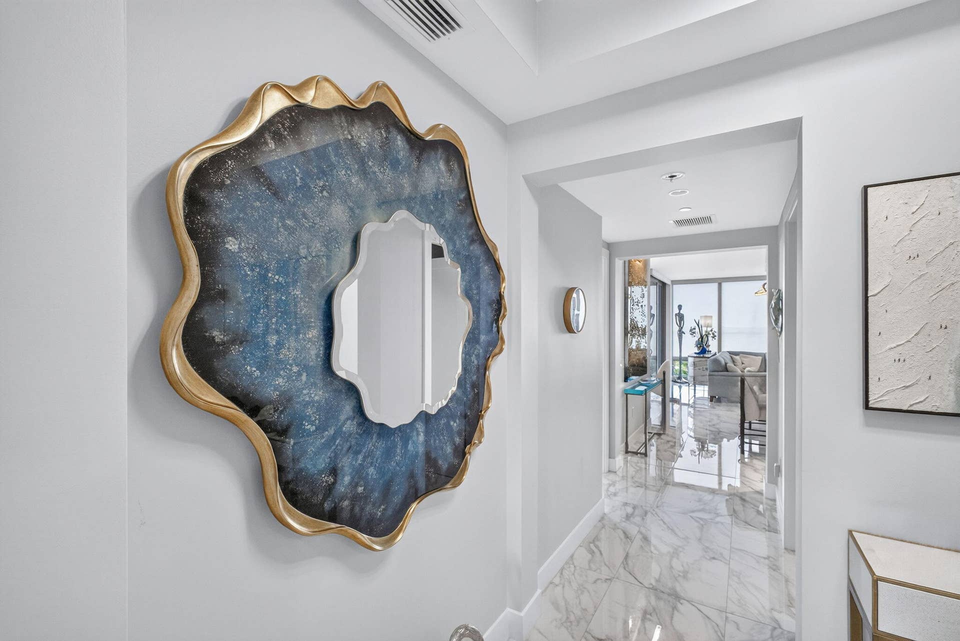1 Water Club Way, #503, North Palm Beach, FL 33408 Hallway featuring marble-finish flooring, recessed lighting, and an archway leading to the East wing or the West wing of the home.