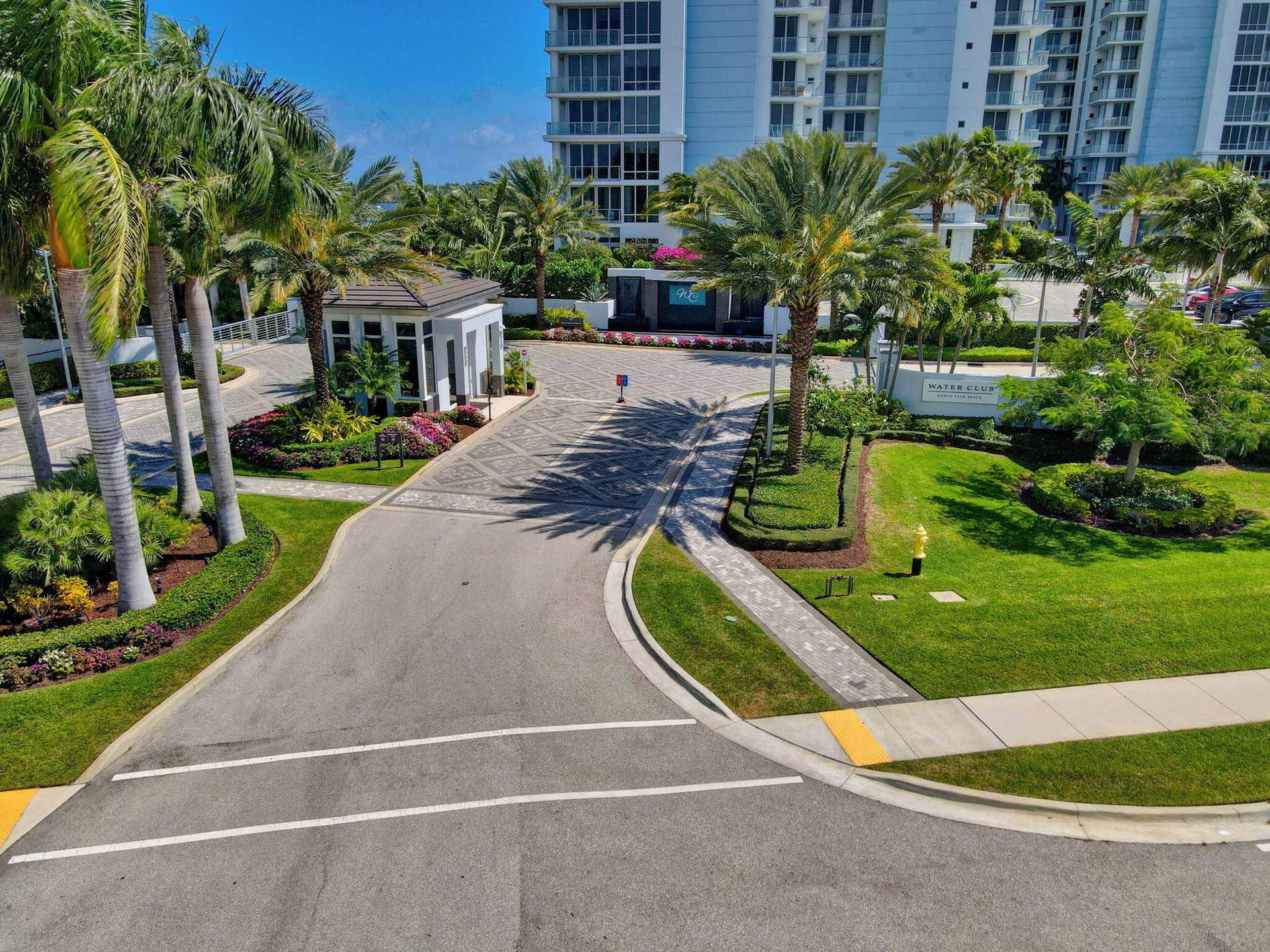 1 Water Club Way, #503, North Palm Beach, FL 33408 Gated entry featuring a guardhouse, extensive landscaping, mature palm trees and security systems.